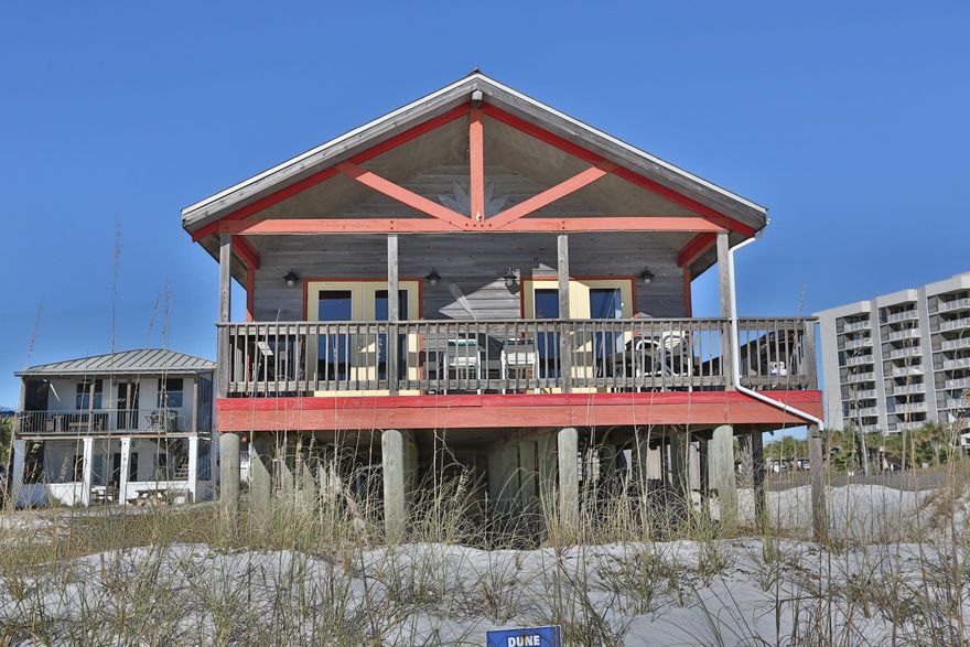 ''Rising Sun'' brings you back to those memorable beach vacations from days gone by. This two bedroom Florida cottage is a classic and is situated right on the white sand beach facing the emerald green waters of the Gulf. A balcony wraps around the side of the home and leads to a spacious covered deck in the back that provides panoramic beachfront views. This charming vacation cottage is an eclectic mix of nostalgia along with up-to-date modern amenities that creates a comfortable and casual setting. The main living area has a cathedral ceiling with exposed beams that give the home a rustic yet spacious look. The large living/dining area features a wall of windows that have westward sunset views across the Gulf. The open kitchen nearby has two sides of marble front bars with five raised