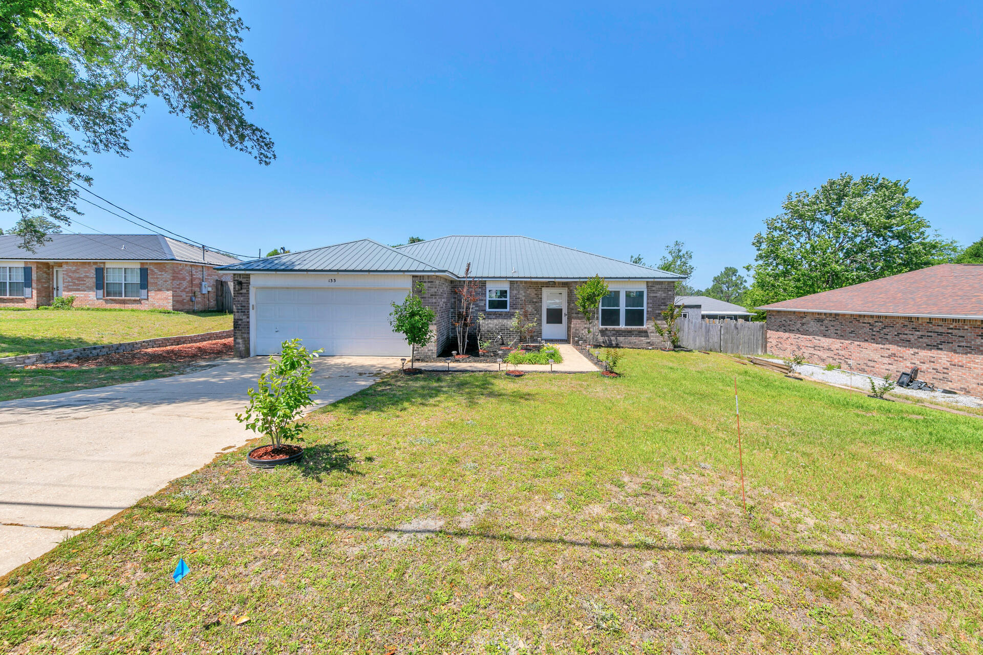 MOVE-IN READY | SOUTH OF I-10 | RV PARKING | SOLAR = $20/MO POWER BILLS. Welcome to 133 Wild Horse Drive, Crestview, FL--an updated, all-brick 3 bed, 2 bath home with a split floor plan and 1,530 SF of comfortable living space. This home features a metal roof, new windows w/ solar screens, new paint & carpet, and wired fiber internet for fast, reliable connection. Solar panels will be paid off--enjoy ultra-low power bills averaging just $20/mo, even in summer! The side yard is perfect for your RV or boat, complete with 50 amp power hook-up--a rare find. The beautifully landscaped yard is all on drip irrigation for easy maintenance. NO HOA. Tucked SOUTH of I-10, it's an easy commute to Niceville, Eglin AFB, or Fort Walton Beach. If you're looking for a well-maintained, affordable home w/ space for toys this one is a must see!