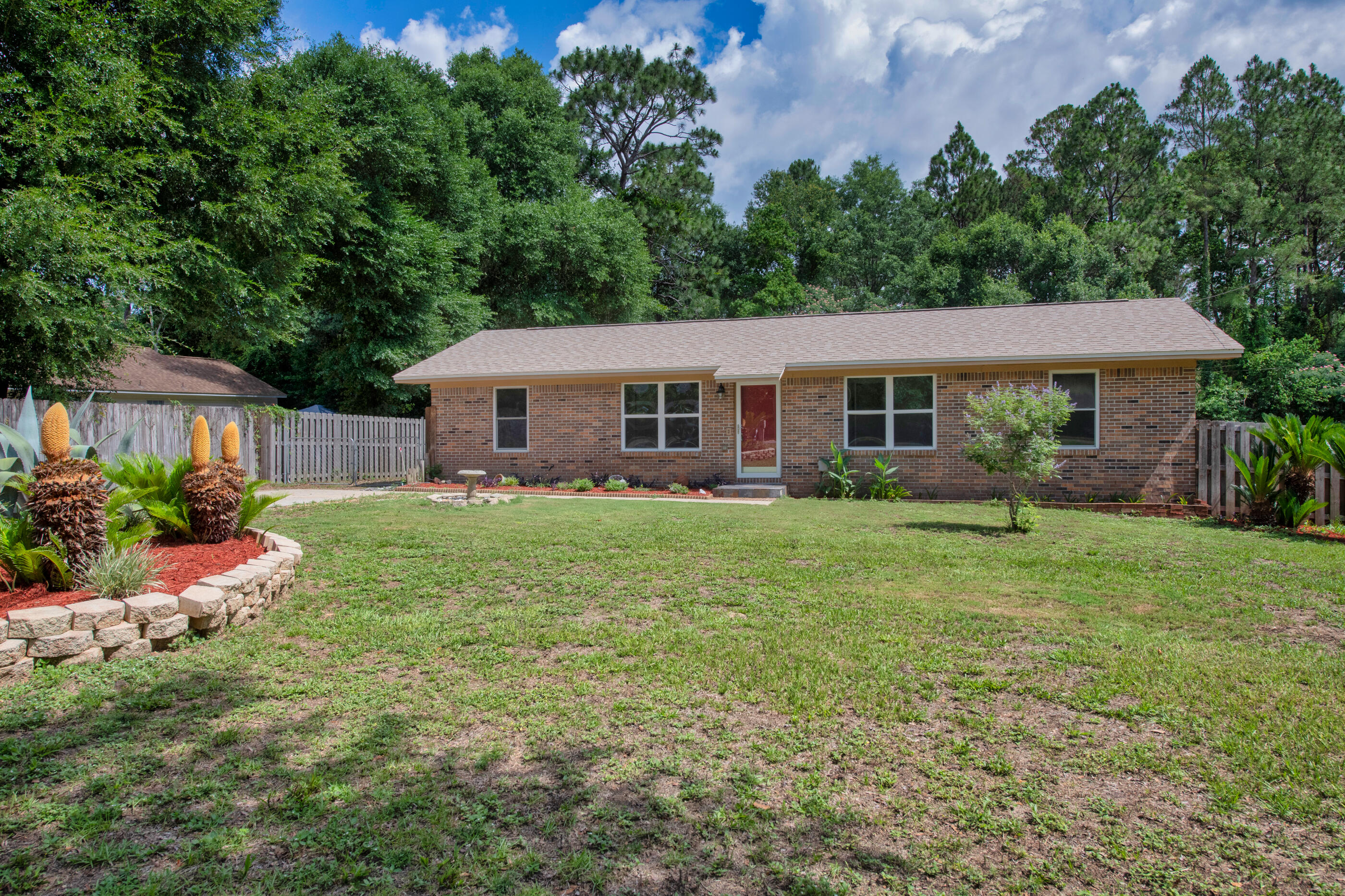 Welcome to your charming retreat in the heart of Crestview! This well-maintained all brick home blends modern updates with classic style, featuring sleek gray vinyl flooring throughout and fresh finishes that give it a crisp, clean feel from the moment you walk in. Both bathrooms have been tastefully renovated offering a touch of comfort where it counts. The spacious front and back yards are perfect for BBQs, tossing a football, or simply enjoying the Florida sunshine. Out back, you'll find a large carport that easily fits two vehicles, a handy shed for all your tools and lawn gear, and even room to park an RV...no HOA drama here! With major systems in great shape you can move in with confidence. This place has a way of feeling like home. HVAC 2017, WH 2015, Roof 2021 and copper plumbing.