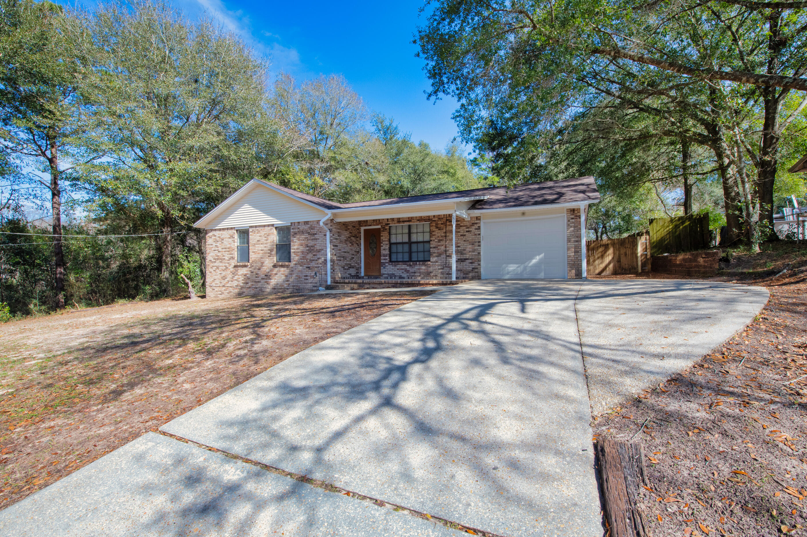 Welcome to this charming home with a huge backyard! The property has a large covered back patio, ideal for cookouts or just entertaining guests. Step inside this all-brick home with an open kitchen and dining combo that has an open wall to make serving people in the living room easy. The kitchen, dining, and baths are beautifully tiled, while the rest of the home has luxury vinyl flooring. Fresh new paint and new blinds give the property a clean and updated feel. Parking is no problem with the added concrete pad. Use it for additional parking or to park your boat; home also has a single-car garage.Close to downtown this home is convenient to all. Don't miss the opportunity to make this property your dream home. Schedule a showing today and experience the comfort and beauty it has to offer!