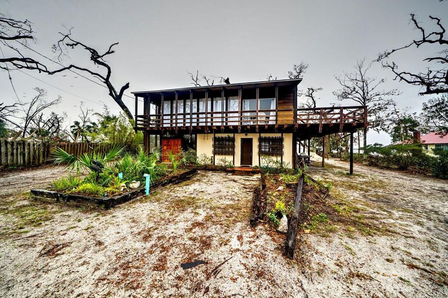 100% financing available for Hurricane Michael disaster victims (rental or owner) via 203h loan. No HOA, no flood insurance required. Comes furnished. Bay County Historians nicknamed this home the ''Hurricane Home'' because it has been used as a safe haven for decades from hurricanes including Opal and Michael. This home has been the entertainment home for families from around the U.S. and has been a wedding venue for many newlyweds. This absolutely spectacular waterfront home boasts 110 waterfront feet, a salt-water / commercial grade infinity pool, and 1 Bedroom / 1 Bathroom apartment that can be utilized as a rental investment property. The main home consists of 2295 square feet of living space with absolutely stunning floor to ceiling windows.
The first floor is massive with an oversized foyer for entertaining, there is also a laundry and storage area with additional square footage necessary for a second kitchen. In addition, the first floor has a large living and family room area for additional sleeping, a large bathroom, a full bath, and absolutely breathtaking views of the bay.
The second floor is world-class and almost every square inch of the walls and ceilings are covered with hand-milled Cypress and Juniper from Apalachicola. 
The kitchen on the second floor has ample room for cabinets and looks right out to a spacious living room and eat-in dining area.
A huge wooden deck surrounded by oak trees overlooks the bay with views as far as the eye can see. Enjoy sunrises and sunsets from your deck and look directly into the infinity pool.
Located on over three quarters of an acre, and right on the water, no HOA, and sleeping arrangements for 18+ people, this one-of-a-kind showstopper of a property is waiting for the perfect buyer.

This is an unbeatable deal for a family or an investor looking to maximize rental potential. With 100% financing, and unlimited upside growth potential for waterfront properties (which are few), this gem of a home will not last long. Schedule your showing today!