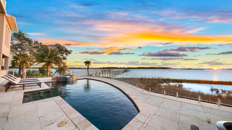 Discover unparalleled luxury on a private island in northwest Florida, where contemporary architecture meets serene tropical beauty. This extraordinary masterpiece was recently featured on HGTV House Hunters Amazing Water Homes in January 2025 and is even more stunning in person than on international TV! As you approach Northshore Islands, you're greeted by only a few homes and this home exudes privacy, exclusivity and remarkable architecture. Built by Rita Jones with the design team of Architect Michael Hunnicutt, and Katie Fisher Design, Interior Design, this exceptional three-story contemporary, modern estate spans over 5,000 square feet, offered fully furnished with NEW furnishings and offers breathtaking waterfront views from every room. Enjoy expansive outdoor living with bay-view covered porches on each level, perfect for soaking in the tranquility of the surroundings on the island. 

Imagine leaving your dock for Shell Island or heading out for a sunset cruise. Picture yourself with the kids by the pool while watching the sun sink into the horizon. This is one of the very few locations in Panama City, Florida that has been built based on the picturesque views and was designed to maximize views of the water from all angles. This private island is a truly a waterfront dream come true! 

For boating and fishing enthusiasts, the property features a private, recently renovated, 350' dock with deep water access to the Gulf of Mexico, which is just 10 nautical miles away with no idle speeds zone in between, offering endless opportunities for fishing and adventure. The dock also holds a 2021 Barletta Pontoon boat on lift and a NEW 40,000 LB boat lift is being installed, ALL of which will convey to the new owner to be able to enjoy the waterfront lifestyle from day one! Not looking for boating adventure? This home offers zero entry into the Bay which is perfect for kayaks, paddleboards and swimming as you watch the picturesque sunset set in the West each day. The island's natural landscaping and soothing bay sounds welcome you to this peaceful retreat, where indoor and outdoor spaces blend seamlessly with a saltwater pool and spa. 

Upon approach to the circular cobblestone paver driveway, you're greeted by sea breezes and a travertine marble tile entry and a foyer framed with a custom Mahogany wood door with artistic blown glass. Entering the main level, the stunning waterfront views stand out as you sit at 23' elevation and enjoy a great room that offers views of the island from all angles. The family room area is framed by custom millwork and a modern linear fireplace surrounded with marble and slate tile creates warmth in the space while framing a wall of full-glass French doors that lead out onto a covered patio overlooking both pool and Bay. From here you can take in gorgeous year-round sunsets as they sink into the horizon each evening. This level also features a light-filled dining room overlooking the natural landscape of the island and a powder room with Onyx walls and custom pedestal sink for guests, and a junior suite overlooking Bay and pool complete with full bath, walk in closet, and Juliet balcony. Luxurious polished travertine tile is consistent throughout the main floor in the great room for a seamless look. 

The open kitchen is fully-equipped and features a custom slab walnut cabinetry, 48'' Thermador Professional convection microwave oven, warming drawer, Viking range hood and full-size Electrolux refrigerator and freezer. A Caesarstone Quartz waterfall countertop island is a showpiece and the oversized island seats 4. The bar and new wine refrigerator are excellent for entertaining and just off the kitchen and adjacent to the 16'x10' walk-in pantry and laundry room with stunning granite countertops, custom cabinetry, washer and dryer and the most perfect views of the island!

The primary suite, just off the kitchen, is a haven of luxury, offering radiant heated Italian porcelain tile floors, a spa-like Grohe walk-in shower with 3 body jets and 2 hand showers, new freestanding tub overlooking the Bay, slab walnut cabinetry with Swarovski crystal knobs and direct access to a waterfront patio with a fireplace. This retreat also features a large 14'x9' closet in the primary suite featuring fully enclosed cabinetry.

The lower level outdoor summer kitchen is an entertainer's dream, overlooking the Bay and pool, is equipped with new luxury appliances, Caesarstone quartz countertops, and custom walnut cabinetry. The pool is framed with luxurious custom tile, Travertine decking and offers new equipment for easy maintenance. With an 18' deep covered patio, your entertaining dreams will become a reality in this world-class outdoor living area. Overlooking the Bay, your boat and the best sunsets that Panama City has to offer - you can't wait to call this one home.

The third level provides a 19"x16" loft living area with remarkable barreled tongue and groove ceiling, waterfront office filled with floor to ceiling glass and doors, and two en suite guest bedrooms, each with walk-in closets and recently renovated luxurious private en suite bathrooms with marble and custom tile finishes.

The lower level includes a 35"x24" 4-car tandem garage, 15"x10" workshop space, media-game room with full kitchenette, full bathroom and a walk-in wine room, ideal for entertaining being just off the outdoor summer kitchen and pool area.

The home's robust construction features cement-filled concrete block walls, hurricane-rated Anderson windows, 150-mph wind rated garage doors, safe room and a 1/2" tempered, frameless glass railing system for unobstructed Bay views. A built-in generator fully powers the second and third floors of the home and there are high-efficiency heat pumps for each floor providing comfort and convenience. A solid, standing seam aluminum roof was installed in 2019. The home has a 500-gallon underground propane tank and infrastructure on the island includes high speed internet, city water and sewer.

This exclusive waterfront home offers a rare opportunity to live the coastal life you've always desired.
