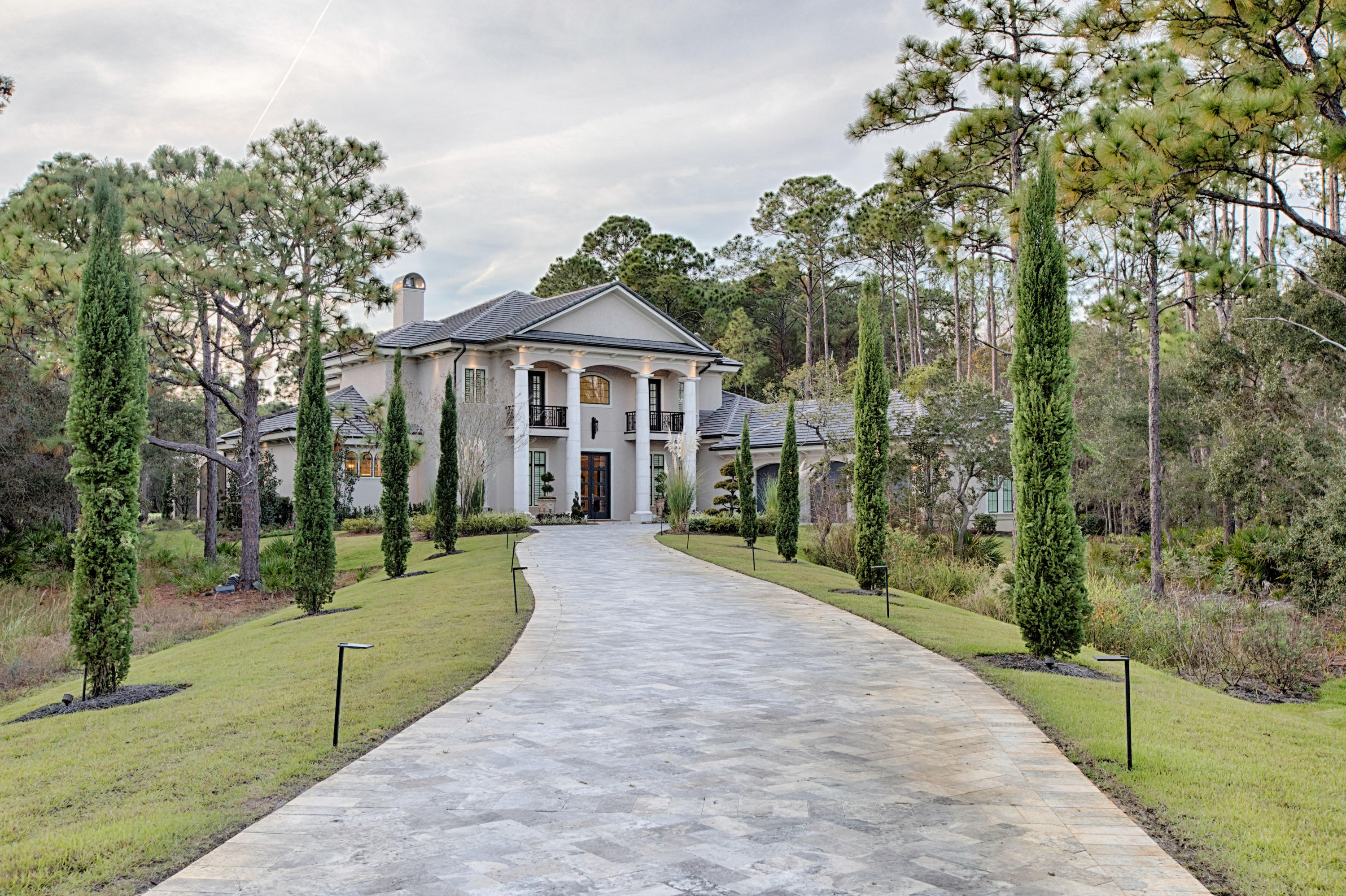 This majestic home located on the 4th hole of the Burnt Pine golf course captures the essence of elegance with the grandest celebration of luxury.  Modern double front doors accented by four stately columns welcome you into a massive open living area illuminated by opulent chandeliers and enhanced by a winding wrought iron banister staircase .  Dark wood beamed ceilings contrast impeccably with cream walls and light marble floors. The unusual aqua mixed granite counter tops of the bar area off of the kitchen demonstrate the design flair of this home.   Emphasized by a colorful backsplash, the gorgeous kitchen also functions incredibly with cabinets that go to the ceiling and three separate work spaces that include two islands.  The open living area seems endless with four oversized patio