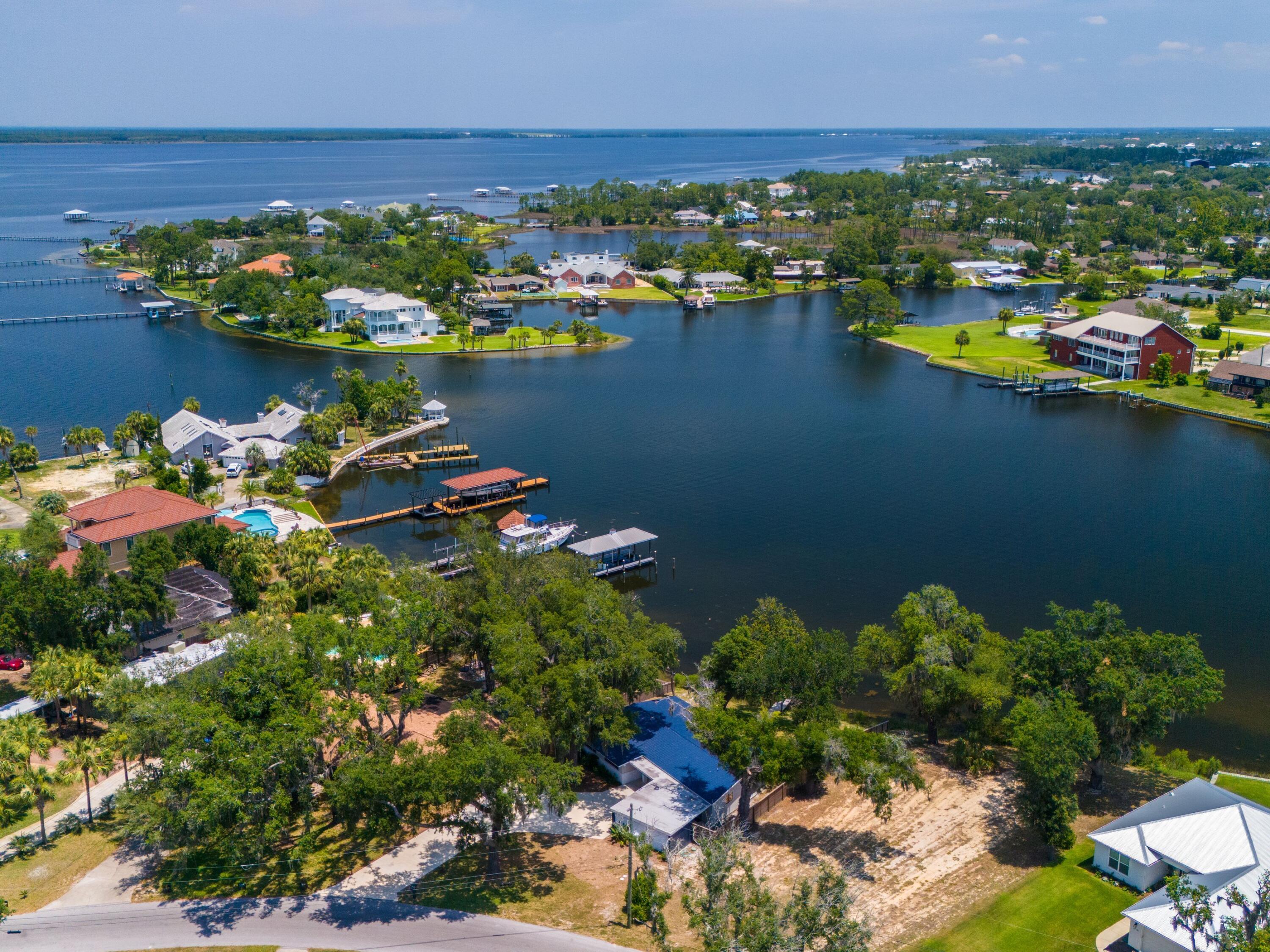 4% owner financing with 20% down for three years offers a developer a low cost to carry having time to complete a home before the loan term ends! Welcome to an exceptional opportunity to own a breathtaking waterfront lot in Panama City. With its idyllic setting featuring mature oak trees adorned with Spanish moss and unparalleled views, this vacant lot presents an incredible canvas for you to create your dream waterfront retreat. Situated on Shoreline Circle, this lot boasts a prime waterfront position, offering stunning panoramic views of Pretty Bayou. Located just nine miles by boat to the Gulf of Mexico, this property is perfect for boating enthusiasts. Indulge in a myriad of activities such as boating, fishing, kayaking, or simply lounging on your private dock. Savor the gentle breeze 80 feet on the water with a natural shoreline and a salvagable dock. This is a rare opportunity to own a piece of waterfront property in such a sought-after location. Whether you envision a serene retreat or an active lifestyle filled with water sports, this lot offers the perfect setting for your future home.