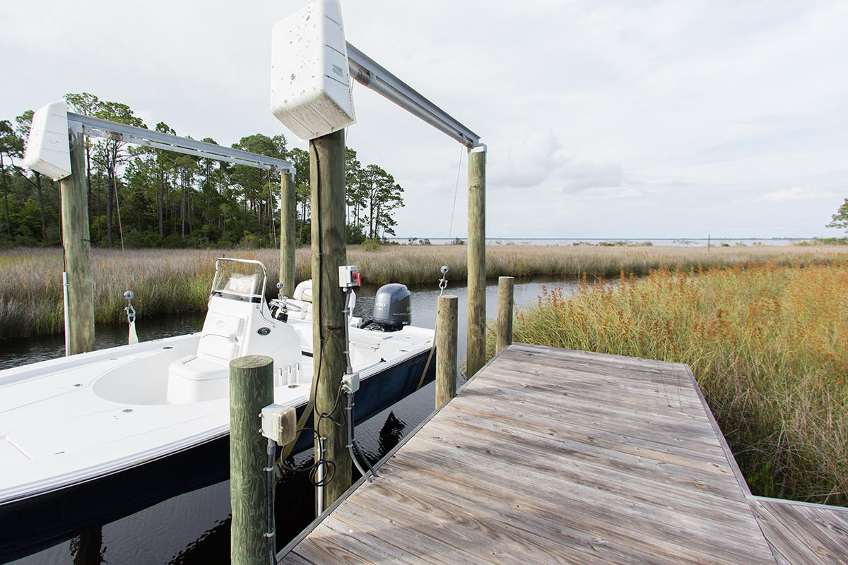 This waterfront, two-story plantation home is custom built and is situated on one acre of lush high and dry woodlands opening to the Choctawhatchee Bay. A boardwalk from the backyard leads to your own private dock and boat lift. The house is set off the main road by a long circular driveway. You will be welcomed by a wide relaxing front porch with a Bevelo gas lantern, front porch swing and mahogany double doors. The expansive rear screened porch makes a great place for entertaining with a large wood burning fireplace and gorgeous views of the bayou and bay. When heading indoors for the evening, your family will enjoy the spacious kitchen and den area along with 5 bedrooms (master on main) and 4 full baths.
