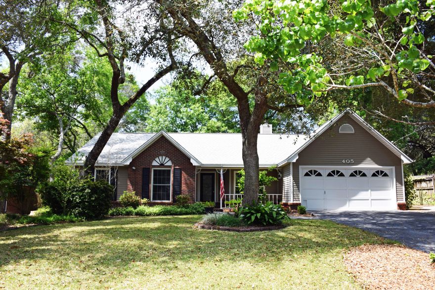 Quietly tucked away on a tree-shaded cul de sac is 405 Seville Circle, a home with cottage STYLE! The welcoming front porch beckons you to come inside and be WOWED by the way the seller has brought the outside in. Natural light from the skylight and the large bay window brightens the great room all day long. It's stunning! The kitchen has been updated with new appliances and granite countertops. Enjoy your meals in the breakfast nook, the pretty dining room (now used as a sitting room), or on the screened porch. There's ample cabinet space in the kitchen and more in the adjacent laundry room. The soothing master suite overlooks the lush backyard and the bubbling fish pond. The tiled bath features a double-sink vanity and a large tiled shower with a seat. Note that there is an outside