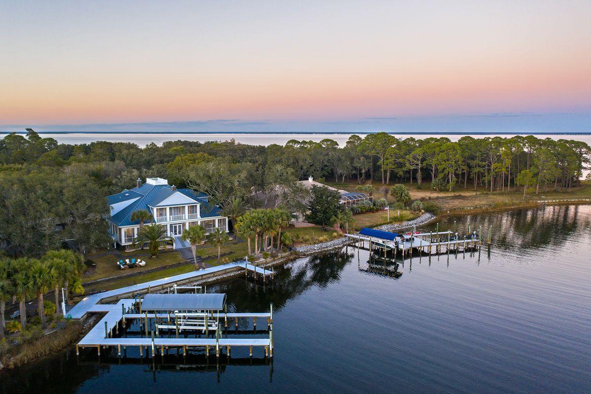 Grand Southern charm meets coastal living in this Low Country-inspired retreat on deep-water Indian Bayou. Nestled amid mature live oak trees on a three-quarter acre lot, this home features deep porches and 225 feet of bayou-front shoreline with no HOA requirements. Significant renovations have been undertaken by the home's current owners including new granite countertops, 60-inch Wolf range with downdrafts, extended tile backsplash, reverse osmosis drinking water system and lighting in the kitchen; new granite countertops, sink, and luxury tile backsplash in the bar area; new quartz counters and sink in the laundry room; and whole-home tankless hot water heater and water softener. Additional remodeling efforts involved two bathrooms on the first floor, the formal dining room, and flooring