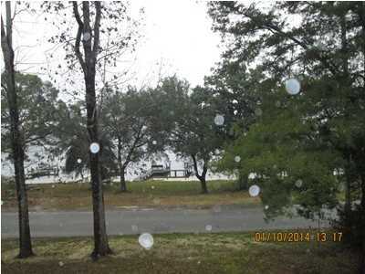 Very nice home with Waterview of Tom's Bayou from Living Room, Kitchen and Master Bedroom. Deep water dock located across street. Spacious covered porch on front of house to sit out and enjoy views of Bayou. Entrance Hall with Wood Paneling and Wood Flooring. On left is Large Kitchen with 6 Burner Jen Aire stove, separate over. Large sit at counter/breakfast area. Wood Flooring. Dining area is Spacious, carpeted, has wood burning Fireplace, wet bar area. Two doors open to Garage area. Very Spacious Family room, Carpeted, sliding glass doors on one side open to Hallway to Two bedrooms downstairs that share a full bath. Double Vanity, Separate Shower, Whirlpool Tub. Both have wood flooring. From Family Room, doors open to Large room that could be Living room, den, sitting room, etc