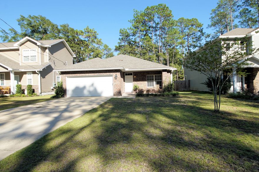 Under contract with kickout clause, accepting backups. Gorgeous home built in 2019 yr with 3 bedrooms, 2 bathrooms, and 1613 square feet in Valparaiso, FL. No flood insurance required, low homeowners' insurance rate, and no HOA! The owner is offering an assumable conventional mortgage at a 4.5% interest rate for a qualifying buyer. This home has been maintained in excellent condition!  This home is close to the military bases, top rated schools in the state of Florida, the white sandy beaches, restaurants, and shopping on the Emerald Coast! Termite bond is active and transferable! Storm shutters are being sold with the home! The interior of the home was professionally painted in 2023. Enter this home through the foyer into the main living area with cathedral ceilings and luxury vinyl plank flooring. The living room opens to the dining room and kitchen. The large kitchen boasts beautiful, custom shaker style cabinetry with a grayish, brown hue, white quartz countertops, white subway tile backsplash, brushed nickel hardware and matching stainless-steel and black appliances. The appliances include a side by side refrigerator with icemaker, a slide in stove/oven, a built in microwave, and stainless dishwasher. Other features of the kitchen include a pantry, raised breakfast bar that seats four to five quests, and pendant lighting. There is a separate large dining room with a chandelier and double window which allows for natural light to abound in the home and provides a view of the back yard. The split floor plan of this home offers the primary bedroom more privacy. Also, the primary bedroom has views of the back yard and an ensuite bathroom with a double vanity, a combination garden tub and shower, and walk-in closet with shelving. There are two additional bedrooms as well as a full guest bathroom. Exterior features of the home include a covered front porch, covered back patio, two-car garage with auto garage door opener, pull-down stairs to attic access, a fenced backyard with single gate, gutters, a Rain Bird sprinkler system, and well-maintained landscaping. The back yard is lined with trees and provides privacy. The roof is a 30 year dimensional shingled roof, the HVAC is electric (2019), and the 50 gallon water heater is electric. This home is light, airy, modern and full of natural light! Buyer to verify all dimensions and information.