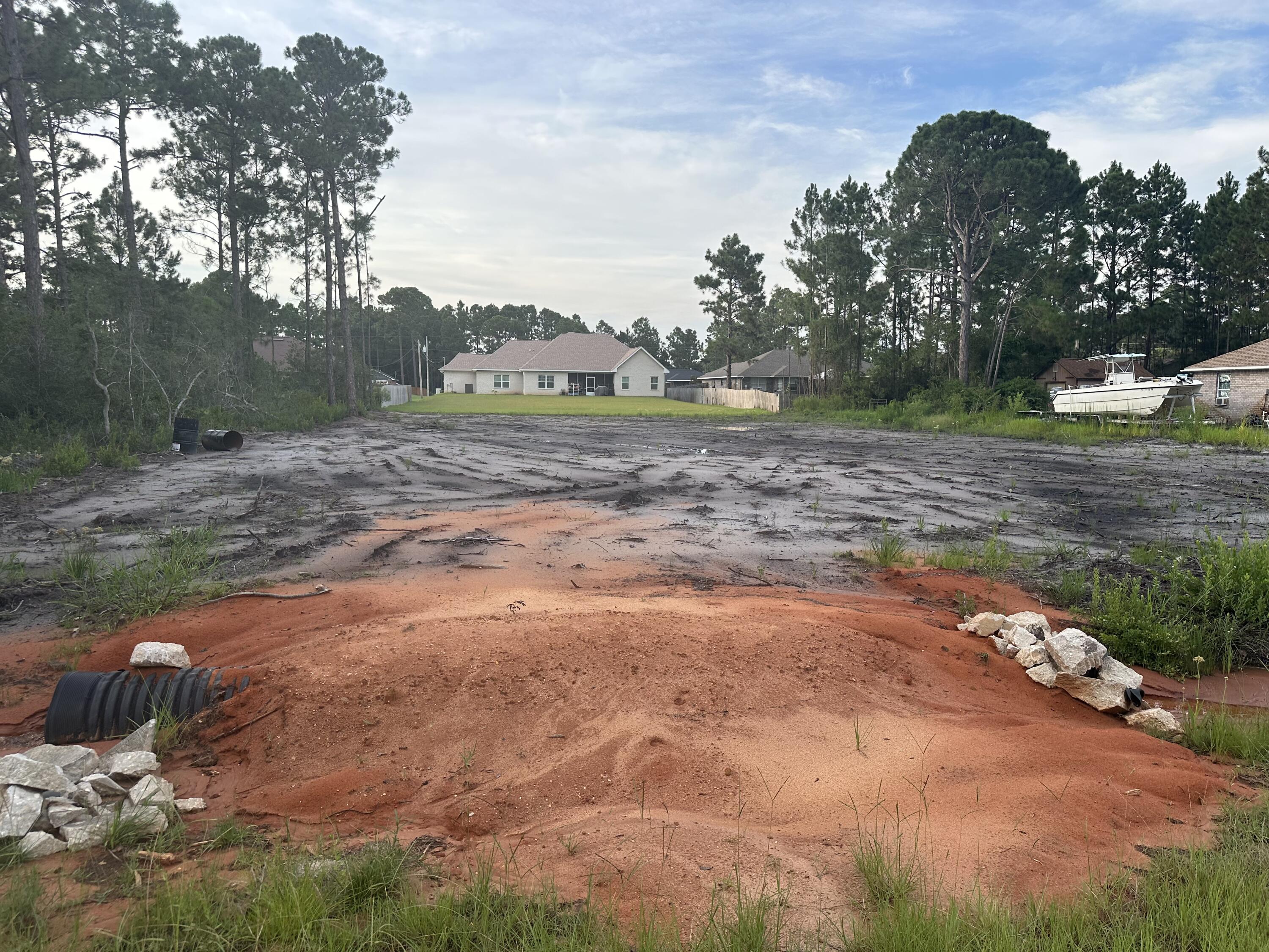 This .46-acre lot offers an ideal canvas for your new dream home. Measuring 100x200ft, the lot has been expertly mitigated and cleared and is ready for construction. All necessary documentation is readily available, including a septic permit, paid water tap, and all relevant building permits. Additionally, a temporary culvert has been installed for convenience and fire hydrant is located on the property line, ensuring the lowest premiums on home insurance. Situated in the Holley by the Sea community, residents have exclusive access to a multi-million dollar recreation center. This facility boasts a full-weight room, three swimming pools, tennis courts, a game room, and various programs for children. Relax in the sauna and steam room, or take advantage of the outdoor amenities, including basketball, handball, and volleyball courts, walking trails, pickleball courts, and grill-equipped pavilions. Residents have access to the Soundside Beach Area, offering a playground, fishing pier and pavilion, picnic areas, and camping sites. For boating convenience a nearby boat ramp and pier off East Bay Blvd, offers boating enthusiasts easy access to the water. If you're envisioning your own dream home, seize this opportunity to own your slice of paradise in Holley by the Sea.