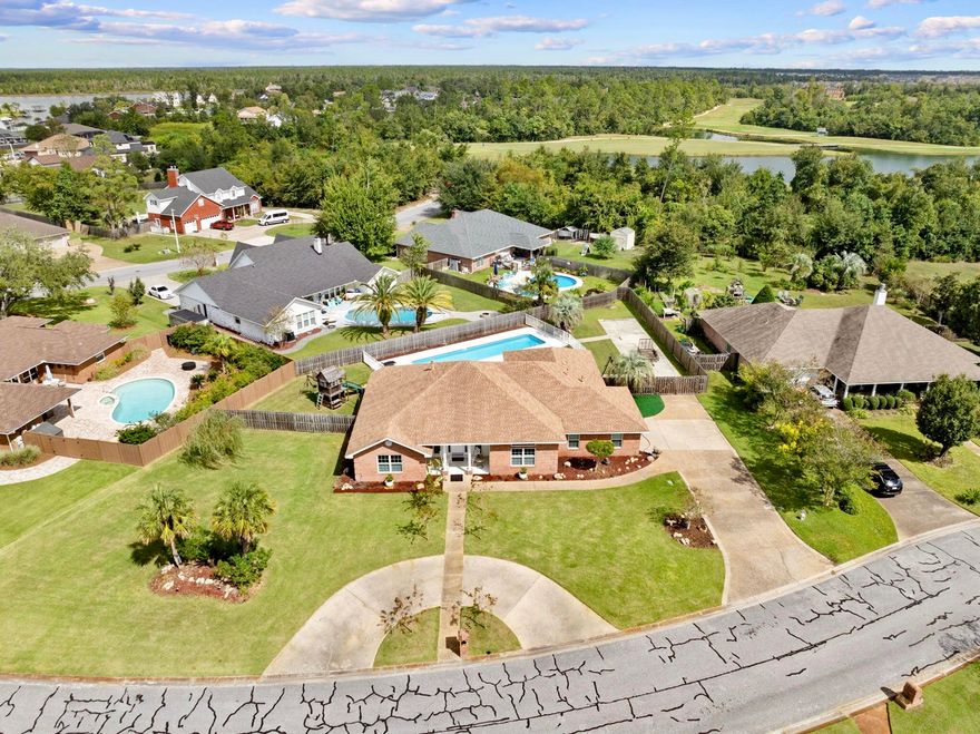 In Bay County, a highly desirable home in Lynn Haven area - Spacious, stylish, and packed with amenities nestled just outside city limits but in the desirable Mill Bayou subdivision, this stunning executive residence sits on a beautifully manicured oversized lot. Designed for comfort and convenience, the property boasts a host of premium features: Outdoor Perks: Enjoy privacy fencing, extra concrete parking, a sparkling in-ground pool, a separate fenced play area and a welcoming circular driveway. Interior Elegance: Step into a grand open-concept layout with soaring 10-foot ceilings. The foyer leads into a spacious living room featuring a wall-mounted electric fireplace set against a stylish feature wall. Entertainer's Dream: The living area opens to a covered porch and expansive pool deck for unforgettable family gatherings. A formal dining room complements the sleek, modern kitchen equipped with stainless steel appliances, a hooded induction range with granite countertops. You will love entertaining with the indoor island hibachi! 

Luxurious Master Suite: The master bedroom offers serene pool views and connects to a spa-like bathroom with dual granite vanities, lighted mirror, a garden tub, separate shower, and private toilet. A massive walk-in closet completes the retreat. Smart Layout: The split floor plan includes three additional bedrooms and a full bathroom on the north wing, with two closets conveniently located in the hallway. Stylish Touches: Custom window blinds allow precise light control, while luxury vinyl plank flooring flows throughout the home. A monitored alarm system adds peace of mind. 

Outdoor Functionality: The backyard is fully enclosed with privacy fencing, and security fencing separates the pool, parking area, and lawn. An outdoor shower on the patio offers a refreshing start before a swim. 

Neighborhood Advantages: Located near shopping, churches, state and county public parks, public boat ramps and recreational opportunities. Approximately 12 miles to Tyndall Air Force Base and six miles to the sandy white beaches of Panama City Beach. 

Efficient Utilities: The home is powered by electricity, with gas servicing the furnace and water heater for optimum efficiency. 

Built to Last: With its brick exterior, vinyl trim, and hip roof, this low-maintenance home promises years of comfort, safety, and style. It is nestled in Flood zone X, no flood insurance required.