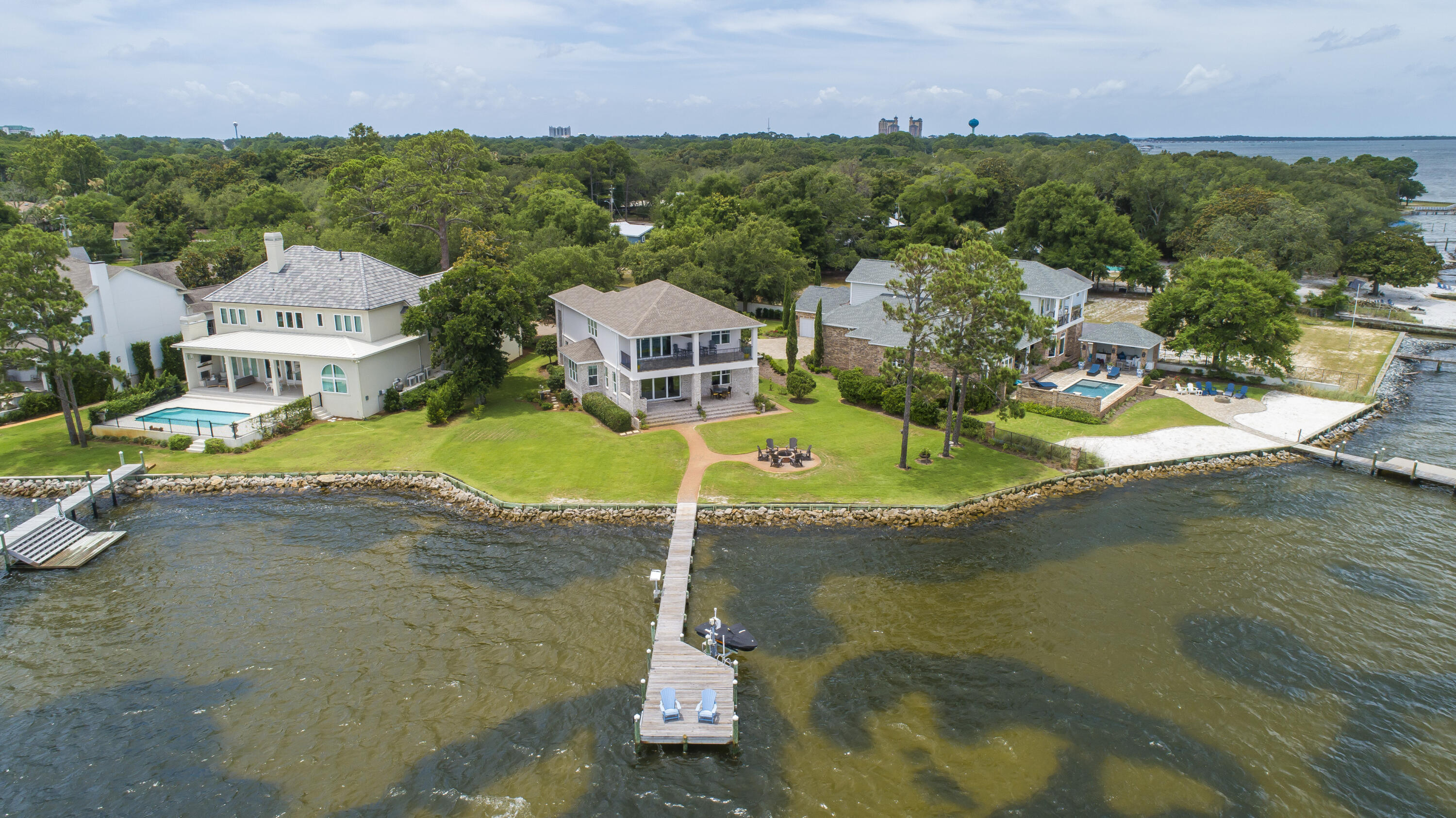 Rare Bayfront opportunity, newer construction built in 2016 In gated community of Peacock's Point. Come take advantage of endless sunsets looking due West from your large covered porch with outdoor Kitchen and firepit. 159' of Bayfront with dock and seawall in place, includes a wave runner lift. Step inside to enjoy the Hardwood floors and gourmet kitchen with a large island and stainless wolf appliances. Recessed lighting 8' interior doors and built in speakers highlight the living space along with a separate dining area. the second floor boasts a large entertainment area with a bar and balcony. Exterior of home is combinationof Brick and Stucco 2 ACs and a Generac generator.