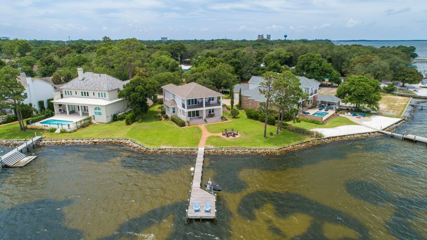 Rare Bayfront opportunity, newer construction built in 2016 In gated community of Peacock's Point. Come take advantage of endless sunsets looking due West from your large covered porch with outdoor Kitchen and  firepit.  159' of Bayfront with dock and seawall in place, includes a wave runner lift. Step inside to enjoy the Hardwood floors and gourmet kitchen with a large island and stainless wolf appliances. Recessed lighting 8' interior doors and built in speakers highlight the living space along with a separate dining area. the second floor boasts a large entertainment area with a bar and balcony. Exterior of home is combinationof Brick and Stucco 2 ACs and a Generac generator.