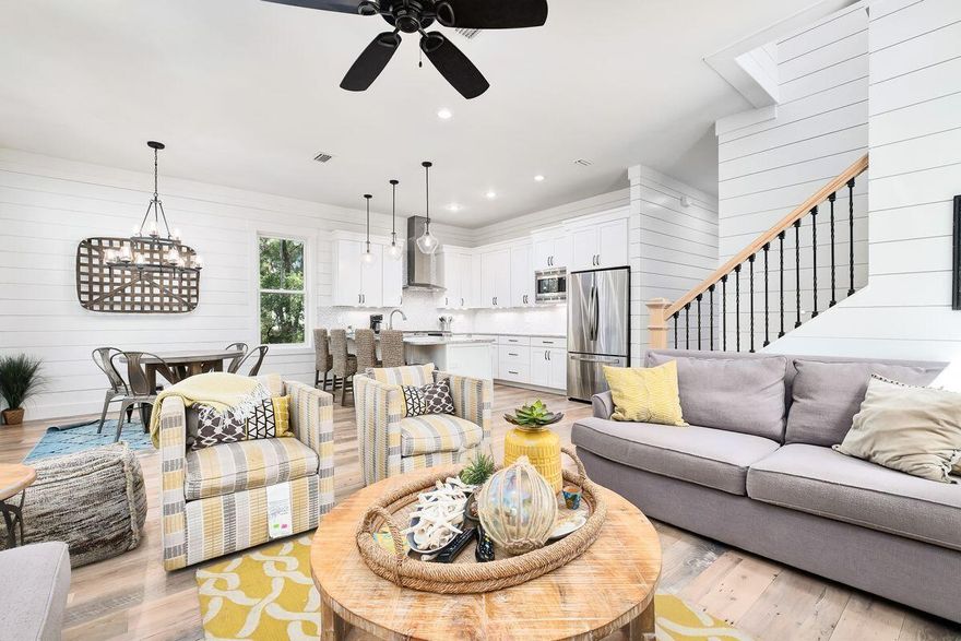 Steps to WaterColor, Seaside, and the beach, this luxury home is enviably located in the gated and lush sanctuary of The Hammocks at Seagrove. The long paved driveway winds through mature greenery to the shady front porch providing a sense of privacy and seclusion. Step inside and admire the distressed hardwood flooring enhanced by 10-ft. ceilings and ample natural daylight. White shiplap walls and panel doors convey a sense of durability. The hallway opens into a contemporary open kitchen with sleek quartz countertops, Bosch appliances, a gas range and generous breakfast bar.  The modern living/dining area opens directly onto an expansive screened deck.