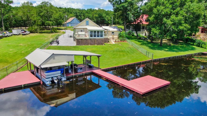 Sparkling example of a perfect waterfront property. Clearly exceptionally maintained, this 3 bed, 2.5 bath would make an ideal getaway or primary home. Newly added 16x13 sunroom & deck with 180 degree water views - hot tub included. Downstairs master suite with new carpet, and convenient access to the laundry room. Two bedrooms and a full bath upstairs. Outside is immaculate and full of extras. From the screened front porch to the multiple carport covers, including one for an RV with 30amp service. The real star of the show is the 'party pad' down by the water, complete with boat house, dock and covered seating. There's even a detached garage that's heated & cooled. You won't find a neater, better cared for property. Come see for yourself to see all the details in person.