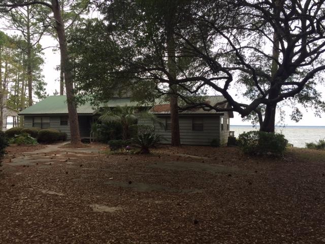 ONE OF THE LARGEST, MOST PRIVATE BAYFRONT LOTS IN SOUTH WALTON. CONVENIENTLY LOCATED AT THE END OF HEWETT PT RD. THIS PROPERTY IS LADEN W/MAGNOLIAS, HUGE OAKS, AZALEAS AND GARDENIAS. THE HOME HAS BEEN USED AS A VACATION GETAWAY AND IS IN NEED OF SOME REPAIRS/UPDATING. SURROUNDED BY WATER, THE WATERFRONT VIEWS FROM THE SCREENED BACKPORCH ARE FANTASTIC! THE WATERFRONT- OVER 400 FEET -INCLUDES BOTH BAY FRONTAGE AND CANAL FRONTAGE THAT WRAPS AROUND THE WEST SIDE OF PROPERTY. SEAWALL AND RIPRAP IS IN PLACE ALONG W/A DOCK, BOATSLIP AND BOATLIFT. THERE IS A DETACHED GARAGE AND ADJACENT CARPORT WHICH IS IDEAL FOR STORING WATERCRAFT.