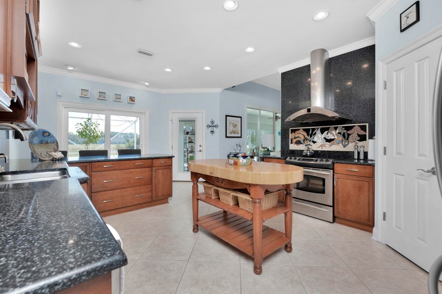 Elegant golf course home offers unparalleled craftsmanship and exceptional amenities! This stucco beauty is truly remarkable inside and out! The notable grounds have been professionally landscaped that boast an array of lush palms that partially shade the pristine yard and oversized brick paver driveway with a convenient side entry garage. From the moment of entry, you will be greeted by the custom-built finishes and attention to detail as you observe the 11-foot ceilings, crown molding, large tiled flooring throughout, and massive picture windows that allow for all the best views of spectacular scenery and the golf course. The main living area flows wonderfully and features an open concept design that involves the large family room with a double sliding glass door leading to the open sunroom, a formal dining room that is open to the kitchen and bar, and a fourth bedroom or office that is separated by a paned door. The gourmet kitchen is perfect for entertaining and includes additional custom finishes that will far exceed your expectations. There is an abundance of upscale cabinetry that is flanked by quartz countertops and a custom backsplash that compliments the homes color palette. Above the oven, there is an impressive granite wall that contains a large stainless hood vent and more custom tile. Other highlights include stainless steel appliances, a built-in dish rack, and hop up bar. From the kitchen you will be led to the master's wing that contains a large laundry room in the hall with built in cabinets and entry to the master suite at the end of the hallway. The master retreat is large with room for an extra sitting area and private access to the screened in lanai. The ensuite master bath features two separate sizeable vanities, water closet, and immense walk-in stylishly tiled shower with double shower heads. Off the bath is the walk-in closet with more custom built-ins for ultimate organization. On the right of home, you will find the guest bedrooms that are opposite the master that contain two full bathrooms. The first guest room includes built in cabinetry that is ideal for crafts or extra storage. The other spare serves as a great guest room that features an ensuite bath with private access to the lanai and backyard. Moving to the expansive outdoor space, you will be impressed with the 1,200 square foot screened in lanai and superb sunroom to enjoy the outdoors while being protected from the weather. You will enjoy all the best Florida days as you overlook the idyllic landscaped grounds and 17th fairway and pond fed by five springs. Don't let this one get away! Call today for a private showing and discover a life of luxury.