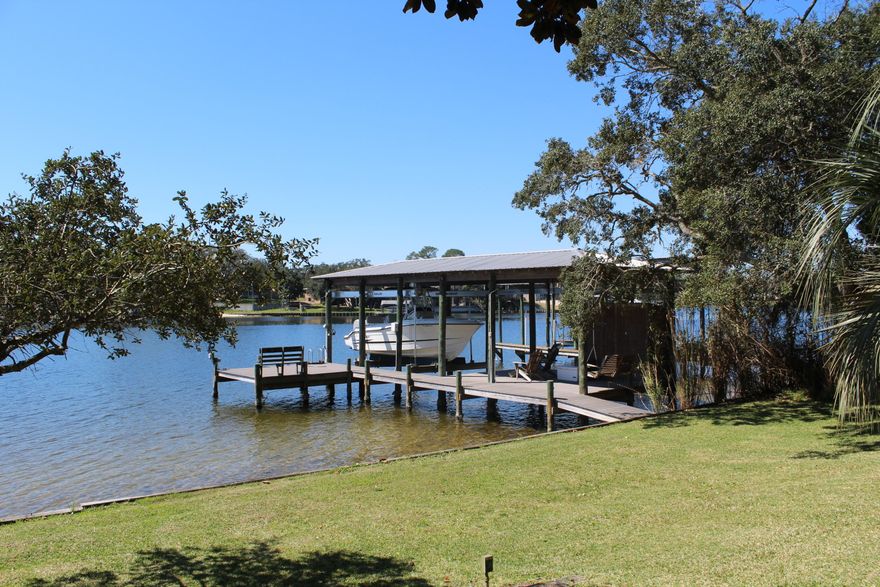 Classic ranch home on a gorgeous deep water lot on Cinco Bayou, graced with mature live oaks and magnolias. Deep lot with 99 feet of bayou frontage, high elevation of approximately 18 feet, beautiful terraced backyard, boathouse with lift. One level home with three bedrooms, two baths, huge waterfront den overlooking the water, large waterfront master bedroom. Porch adjacent to the den is 41 feet long. If you love to boat, this could be your new address....it's just a short boat ride to the bay, Crab Island, Destin Harbor and the Gulf! As always, all dimensions important to the buyer should be verified. No HOA fees!