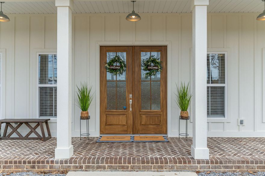 Experience modern farmhouse living in this meticulously crafted home, nestled on a spacious one-acre lot. With approximately one-third acre of wooded privacy in the rear, this property offers tranquility. Capture breathtaking sunsets from the expansive front porch adorned with stately columns, brick inlaid flooring featuring a herringbone design and a 8' tall 4-lite double front door.Step inside to discover elevated ceilings, artisanal trim work and an open floor plan that includes a wide foyer, a versatile office/flex space, and a generous living area. Eye catching built-ins enhance the inviting gas fireplace, while the adjacent dining room, with glass panel pocket doors, adds to the charm.The kitchen is a culinary haven with luxurious cabinetry, soft-close drawers/doors, quartz countertops, and massive 5'x8' center island & breakfast bar. Stainless steel appliances complement the beautiful farmhouse sink, positioned in front of a triple window overlooking the backyard.
The split floor plan highlights two secondary bedrooms with a Jack-N-Jill bathroom, while the primary suite offers ample space, featuring a soaking tub, large tiled shower with a zero entry, and a walk-in closet with custom built-ins. The closet seamlessly transitions into a well-appointed laundry room with an abundance of cabinet and storage space.
Step outside to a covered rear patio leading to your sparkling in-ground saltwater gunite pool, with in-water ledge seating  and a large fenced backyard area - an ideal setting for entertaining and family gatherings.
Beyond the two-car garage, an additional garage space awaits to accommodate all your projects, yard tools, and recreational vehicles/toys. 
This is Southern living at its finest. Don't miss the opportunity to make this extraordinary residence yours - schedule your appointment today.  ***COUNTY TAXES & NO HOA*** Look for a list of the Custom Features in the photo section. 
