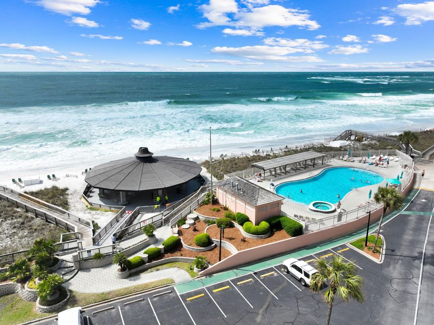 Located on popular Holiday Isle, this oversized one-bed, one-bath beachfront condo lives large and comes with access to a beachfront pool and outstanding amenities. As one of the largest one bedroom floor plans in the building, this generous unit has an impressive rental history. It includes some new furniture and a new HVAC, replaced in 2024. Step through the door and appreciate the open spaciousness and tile flooring that flows through the living area. Sliding glass doors open onto a covered balcony for dining and relaxing with refreshing coastal breezes and views of Destin Pass. Relax in your favorite armchair watching TV or out on the balcony enjoying the ever-changing scenery of boats by day and stunning sunsets in the evening. The generously L-shaped kitchen is well appointed for longer stays with a full range of appliances. The mosaic tile backsplash adds a touch of color to this well-appointed space. Four stools are lined up beneath pendular lights at the breakfast bar, supplementing the formal dining table. The bedroom is a sanctuary of tranquillity with wood plank flooring and fresh white decor. There's a shower/tub combo and a granite-topped vanity in the family bathroom. The unit also benefits from a stacked washer/dryer. Nestled in the waterfront community of Jetty East, this spacious condo provides covered parking and access to a resort-style pool, hot tub, tennis courts, fitness room and use of the beachfront pavilion/gazebo where live entertainment is offered in season. The nearby harbor is home to some of the best seafood restaurants in the area. Don't miss this opportunity to secure an amazing condo for your future vacations, with optional rental income when not in use by the owner. 