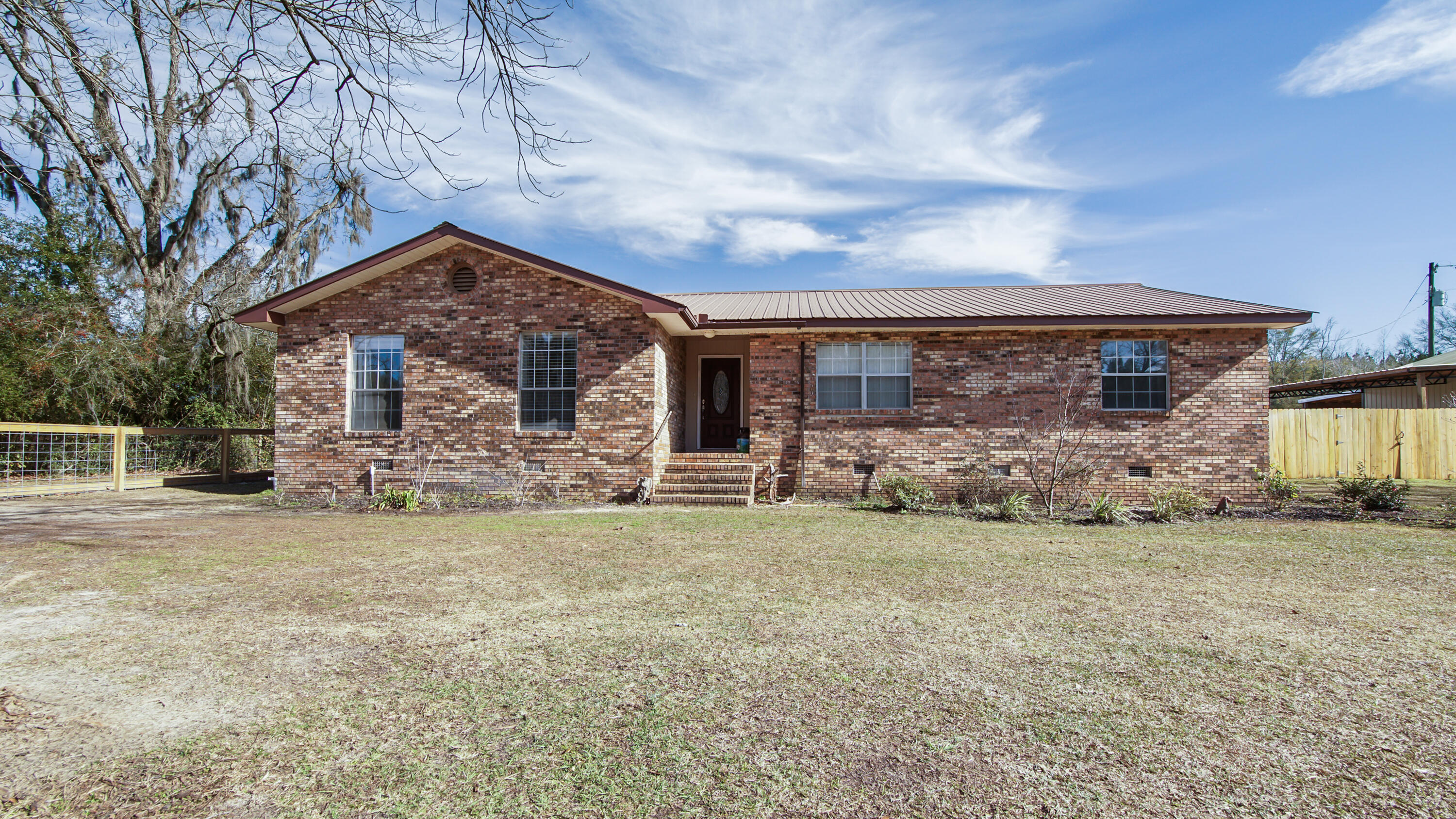 This charming, beautifully maintained, brick home is situated on 1.4 acres. The property is completely fenced and cross-fenced for peace of mind for your pets. The home features a large living room, remodeled kitchen with granite countertops, breakfast bar and the 20x8 Florida room, perfect for entertaining. The fully landscaped yard has a 7-zone irrigation system in place. There is a detached 48x32garage/shop featuring 3 roll up doors, loft storage, 9,000 lb. lift. There is covered parking for 4 vehicles. Also located on the property is a separate power pole with 50-amp service and a 2nd septic tank for your RV. A storage shed near the garage is equipped with water and electricity, having the potential for a she-shed or man-cave. This home is located just 10 miles from Cypress Springs, known for its crystal-clear water perfect for kayaking and canoeing adventures. The white-sandy beaches of Panama City Beach are just 45 minutes away! This home must be seen to be fully appreciated. 