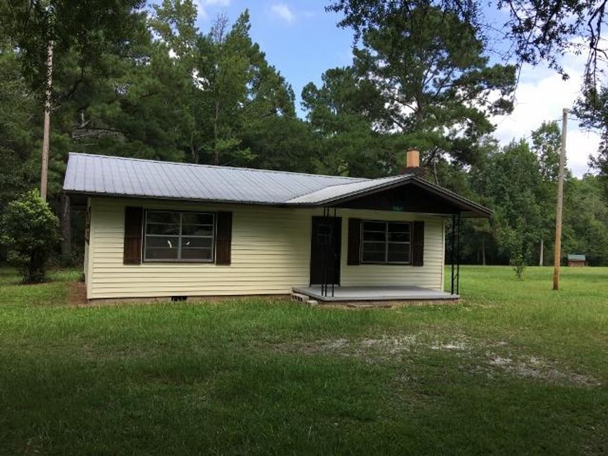 This 2 bedroom and 1 bath home is situated on 1.53 acres and offers you privacy with the convenience of town. With a foundation of great bones, including the metal roof and minimal maintenance exterior this home could easily be your perfect escape to the country. The living area features a brick fireplace adding to the coziness of this home. The kitchen has a brand new stainless-steel refrigerator and gas stove, with a quaint eat- in nook filled with lots of natural light. It has beautiful wood floors in the living room, kitchen and eat-in nook and carpet in the bedrooms. Enjoy the start to your day with a cup of coffee and your favorite book on the front porch. There's plenty of room for gardening or entertaining! This home is easily assessed by a paved road.