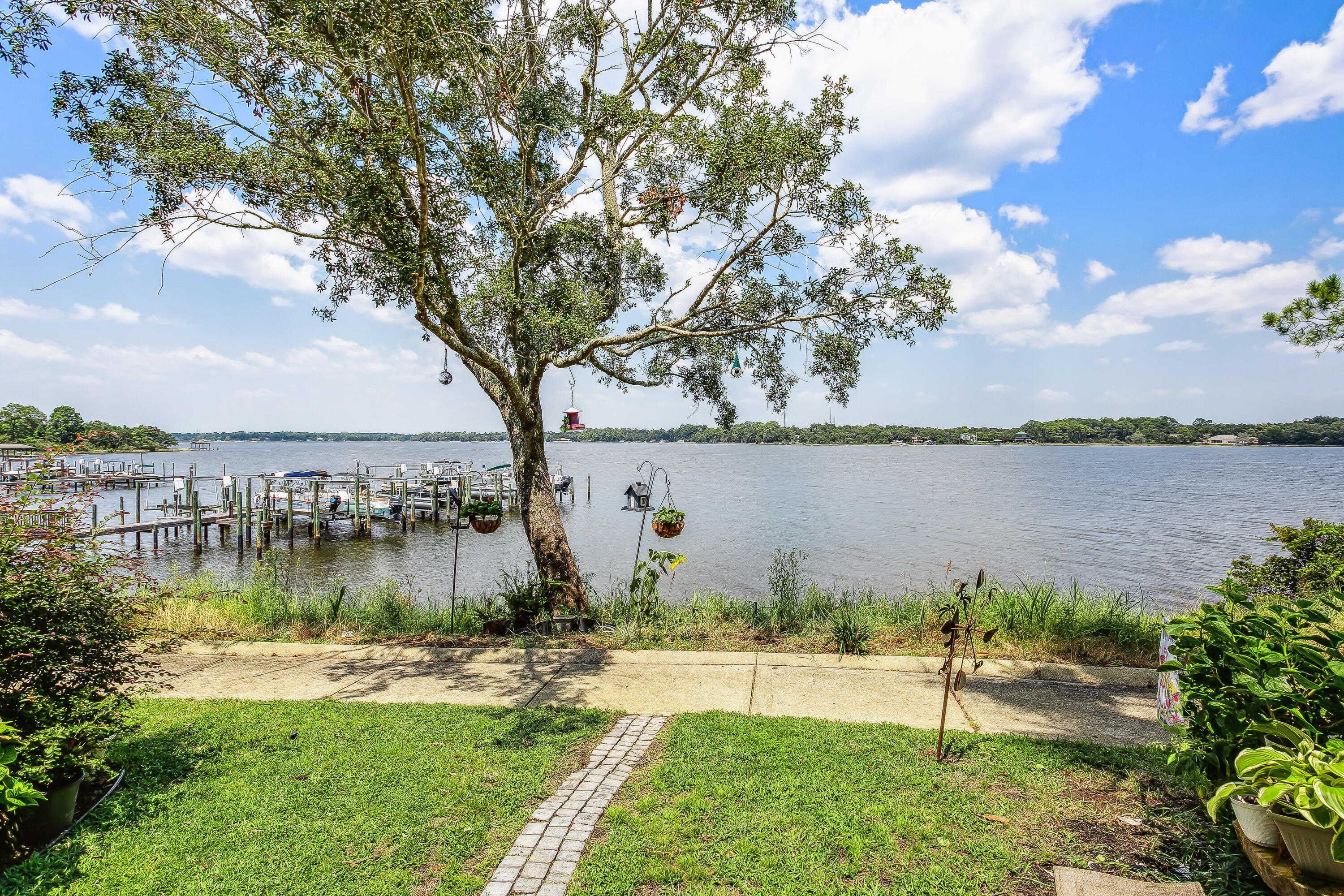 Enjoy waterfront living & stunning sunsets from this 3 bedroom townhome. As you enter the home, you will find a split bedroom & full bathroom & then an open concept kitchen, dining and living area with double french doors that lead out to the back patio & overlooks beautiful East Bay. The kitchen has leather granite countertops, 36 in upper cabinets & all stainless appliances. Second floor has an additional bedroom with its own ensuite full bathroom and the primary bedroom with its own balcony. The primary bathroom has a garden tub, separate oversized shower. The 3rd floor bonus room offers even more breathtaking views & another balcony. New exterior paint and 2 kayak racks included for you to enjoy the open waters of the Bay! Truly a rare find in Navarre! NEW ROOF with acceptable offer!