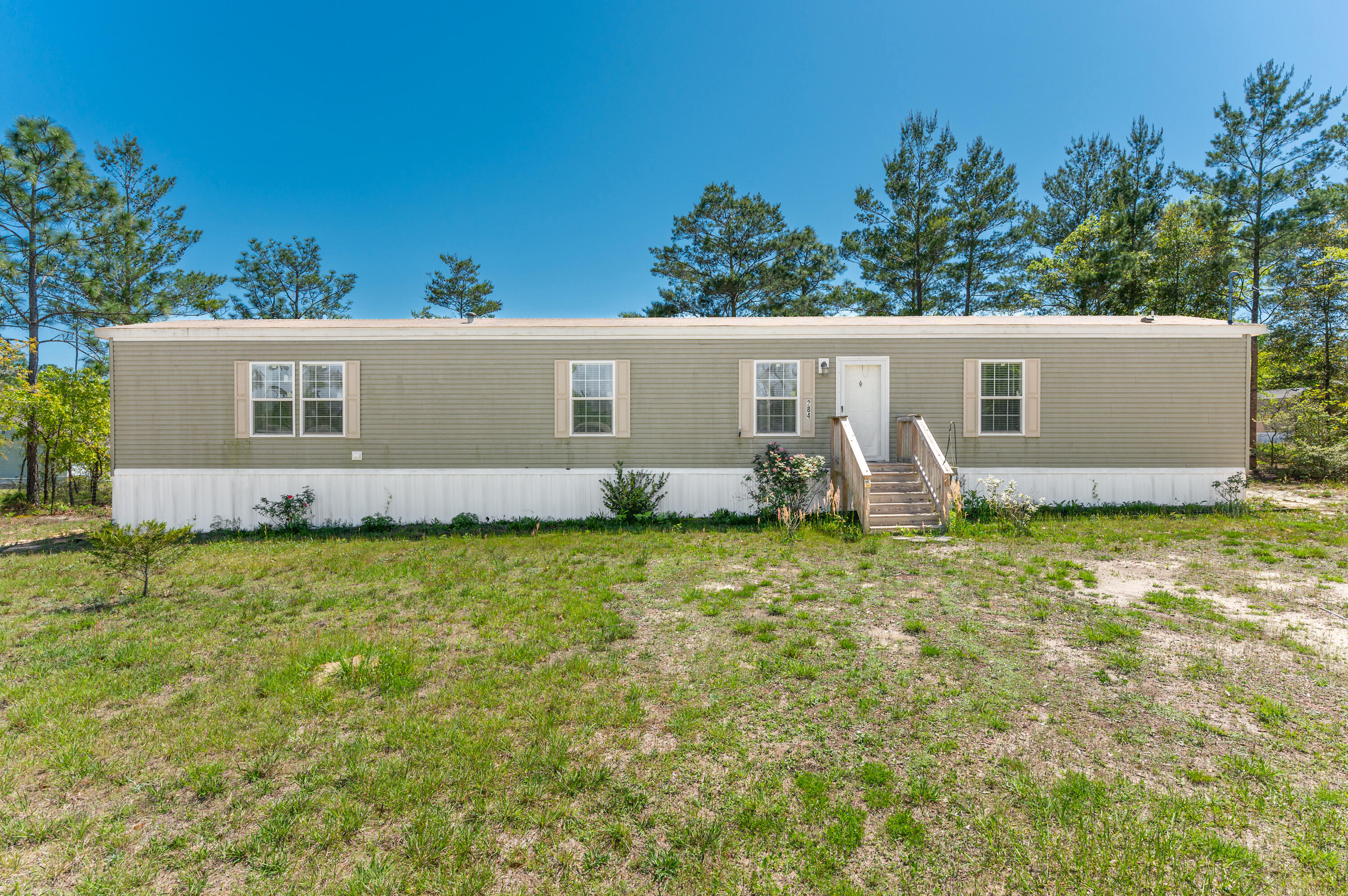 Experience peaceful country living at 284 E Iris Ln! This 3-bedroom, 2-bathroom manufactured home sits on 0.68 acres, providing plenty of space to enjoy the outdoors. The split floor plan offers privacy and functionality, with the primary suite on one side of the home and the additional bedrooms on the other. The spacious living area flows seamlessly into the well-appointed kitchen, which features ample cabinet space and modern appliances. The primary suite boasts a private bath, creating a relaxing retreat, while the secondary bedrooms share a full bathroom. Outside, the large yard provides endless possibilities for gardening, outdoor activities, or simply unwinding in a peaceful setting. Located in a quiet area yet still convenient to local amenities.