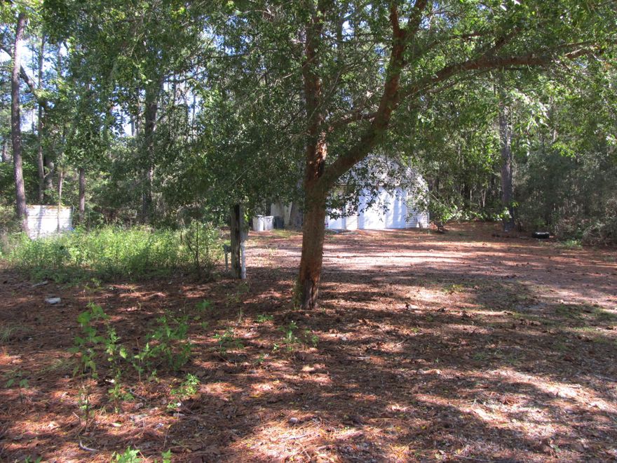 Great parcel with improvements ready for your next home. Property includes 20x30 workshop which has small bathroom with shower.as well as fireplace for cool evenings. Property once had a small manufactured home on property as well. First thing you will notice upon entering property is the large trees that creates a beautiful canopy. All utilities are in place so just bring your imagination. This would make a beautiful home site. Don't miss out.