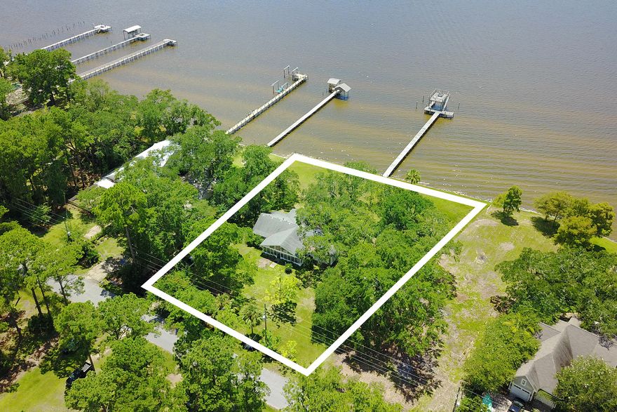 Rare opportunity to own a charming 4 bedroom, 2 bath home on a large bay front lot in Freeport. With 196 feet of frontage along the Choctawhatchee Bay, here you will enjoy incredible sunsets as well as a huge backyard for family and entertaining. Located just north of the 331 bridge and a short 15 minute drive to South Walton's sought after beaches, this home offers an open living, dining and kitchen area that leads to one of the two large enclosed patios - the perfect spot to unwind and relax. The kitchen boasts plenty of space including an oversized bar that can easily sit five people. With four spacious bedrooms this home is an ideal choice for anyone wanting privacy and plenty of room to roam! The long dock is able to accommodate several boats along with a viewing platform.