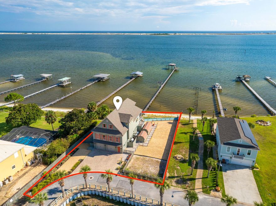 A Rare Find. 101' Soundfront DOUBLE LOT with Private Boat Dock, Panoramic Views, and Custom Details Throughout. Boasting combined 101' Santa Rosa Sound frontage, this stunning residence offers a lifestyle defined by waterfront living and timeless design. Set on two separate soundfront lots with respective water frontage of 61' and 40' offers options to add a pool & spa, putting green, cabana with fireplace OR selling the second lot to build a second home. The property highlights panoramic views of the Santa Rosa Sound and the Gulf just over the barrier island.&#8232;Spanning 2,770 sq ft, the home offers 3 bedrooms, a versatile flex space, 2 full baths, and 2 half baths. The interiors are filled with thoughtful craftsmanship, including hand-selected wide plank heart pine floors reclaimed from an Old Crow Distillery warehouse and 1x6 pine ceilings in the communal areas and primary suite. 
The open-concept kitchen, dining, living, and lounge area is anchored by an oversized island with additional storage, granite countertops, a renowned La Cornue 5-burner range, and antique armoires repurposed as functional cabinetry. The bathrooms feature tumbled stone showers and antique, refurbished cabinet vanities, blending luxury with functional character.
The split floor plan ensures privacy, with the soundfront primary suite encompassing the entire 3rd floor. This retreat includes a private balcony overlooking the water and a flex space ideal for a home office or private lounge. The 2nd floor boasts 10' ceilings and panoramic Sound views from all communal spaces.
Practicality meets luxury with a finished garage with A/C ( not included in home's sq footage) built-in cabinets, sectional dividers with space for hobby room, family retreat/TV area, a half bath, and an additional laundry. 
Parking is abundant, with driveway space for 4 cars and garage capacity for up to 6 cars, two laundry rooms, a tankless water heater, a whole-house Generac generator, and Located just minutes from Florida's Best Kept Secret, Navarre Beach. 
Experience the best of the Navarre Beach lifestyle with access to the Navarre Beach Fishing Pier, miles of bike/walking trails, and the Gulf Islands National Seashore's natural beauty. Just over the National Seashore is Pensacola Beach for even more Entertainment, Shops, and Restaurants.
This exceptional waterfront home combines peace of mind with unparalleled amenitiesan extraordinary opportunity to own a truly unique Soundfront property.
