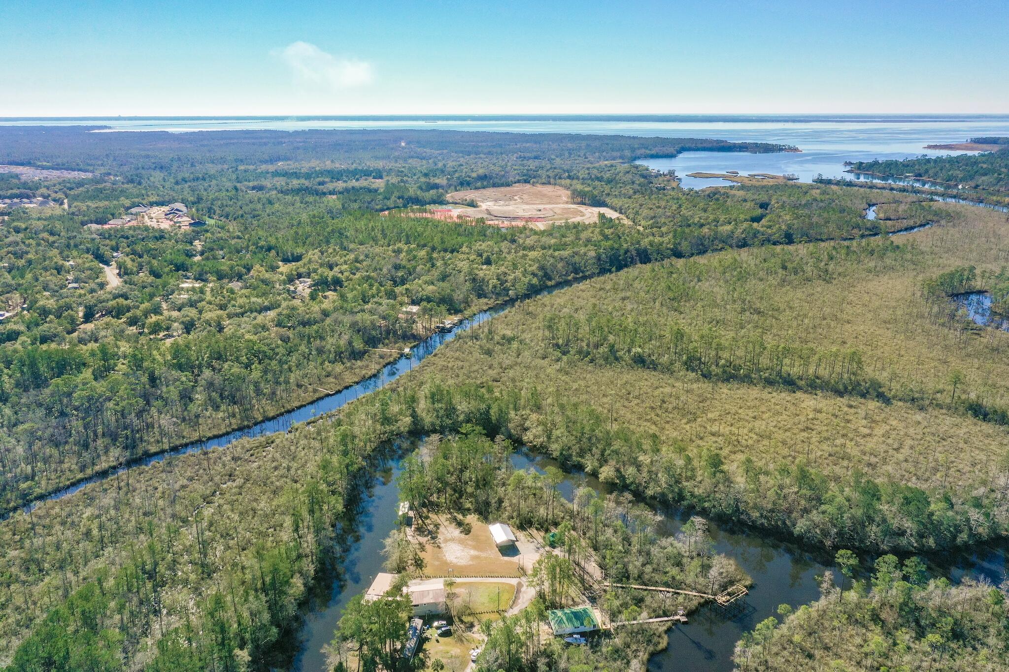 A perfect opportunity to build your dream, private hideway in Freeport, Florida less than 30 min to the beach! This property offers flowing straights on three sides from the impressive Alaqua River. Build your private estate or use the property as a camp or cabin getaway. This property features a boat dock and lift, and two large metal warehouses for a multitude of storage and shelter applications. Septic permit available, electricity on lot. No HOA or buildout time! All dimensions and acreage to be verified by buyer.