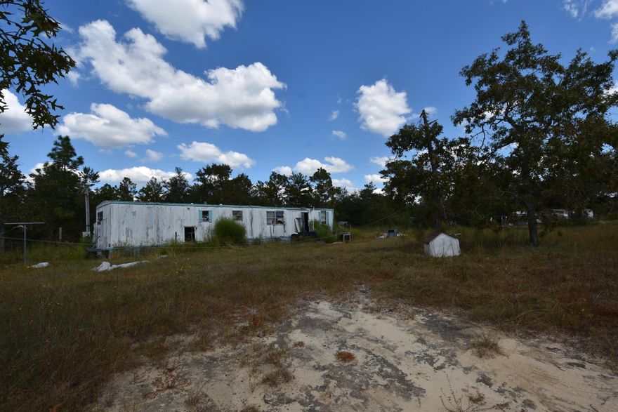 Level land not far from town. This is an unusual property with the property as it is now includes Grady Johnson Road, which is not maintained by the county. Check out the aerial in the Photos. 2 parcels that are included are: #1 is .95 acre and #2 is .77 acre. See the Tax Plat in the Photos. Zoning is AA and Future Land Use is Agricultural. Please verify all info including utilities and farm animals allowed. Mobile Home is not livable and conveys, as do any and all utilities, ''AS IS''.