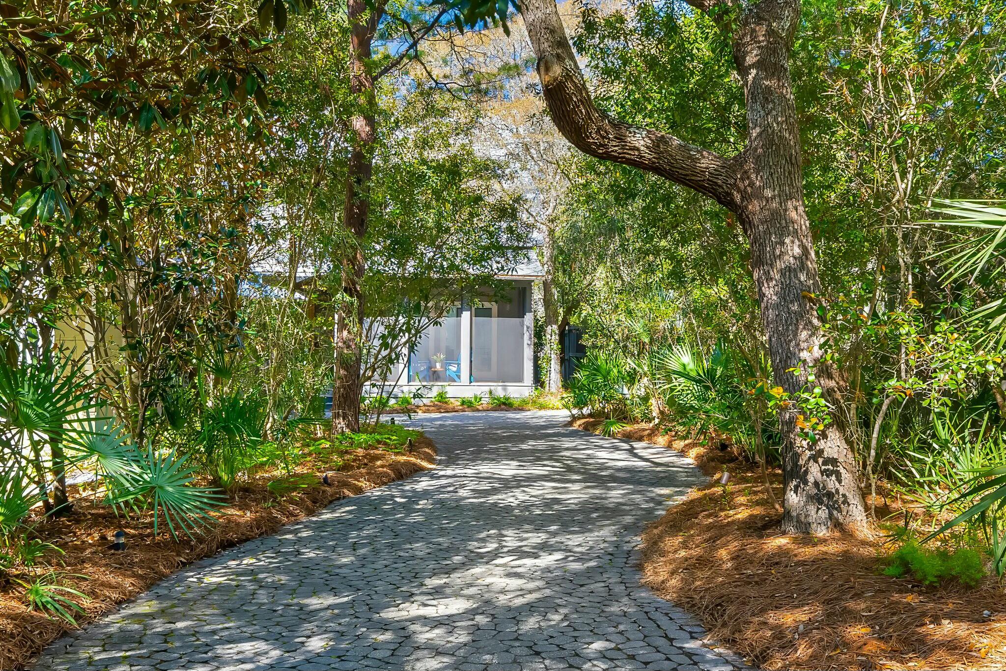 **Unique Seagrove Home With Exclusive Features In A Highly Sought After Location**Welcome to 163 Hammock Ln., a distinctive 15-room house located in the desirable Hammocks of Seagrove, Florida. This 3400 square foot home is nestled amidst lush greenery and natural beauty. This is the largest lot in the quaint subdivision and not only the most private in the Hammocks, but possibly the most private and secluded along 30A while still being in the midst of all the action! Enjoy the 2 pools in the subdivision or there's room to build your own. The property has the only home in the neighborhood with a garage and a separate guest suite, which sleeps 4. There's even room to expand on this lot!
Upon arrival, the long driveway sets a serene tone, leading you to fall in love at first sight. This home has had only one owner, the builder, and has never been rented. The property has been meticulously maintained and features magnificent reclaimed wood flooring and beams throughout. All walls are adorned with shiplap, providing a cozy and inviting ambiance.
The open floor plan welcomes you with a seamless flow from room to room. The spacious kitchen is a standout, featuring an array of high-end appliances including a Sub~zero refrigerator, a six-burner freestanding KitchenAid stove with griddle, a large capacity oven, and a smaller convection oven. The kitchen also boasts antimicrobial zinc countertops, a farmhouse sink with commercial-grade chrome fixtures, a KitchenAid dishwasher, and natural lighting throughout. The 10-foot island has a bistro-style counter with ample seating, making it a focal point for gatherings. Additionally, a large walk-in pantry offers extra storage with an additional refrigerator and freezer. The dining room enhances possibilities with a 9 ft. table and convenient dry bar.
The living room provides a perfect gathering space. Large windows surround the living area, allowing natural light to flood in. Glass panel French doors open onto a screened porch, offering an ideal spot for evening relaxation. Another set of double doors leads to an extremely private side deck. The property is surrounded by mature magnolias, live oaks, and pines, creating a peaceful environment. A nearby canal and the ocean's gentle sounds add to the serene atmosphere. The lot is uniquely positioned to accommodate a private pool.
The master bedroom is conveniently located on the first floor, featuring massive his-and-her closets, and a bonus walk-in closet for additional storage, and a master ensuite with a spacious shower, soaking tub, separate toilet/bidet, and double back-to-back vanities.
The home includes a total of 4 1/2 bathrooms, each tastefully decorated with marble floors, glass doors, and neutral white walls. The accents in pillows, linens, and towels allow for personalized touches to match any style.
Upstairs, the loft overlooks the living room and kitchen, offering panoramic views of the incredible lush vegetation on this lot. This dramatic space showcases Florida's natural beauty! Off the loft area are three additional bedrooms and 2 baths.
Upgrades include a central vacuum system, whole house water filtration system, security system, two outdoor showers, and a storage building with all the space you'd hoped for.
Located in Seagrove, this property is within walking distance to one of the Gulf Coast's most beautiful beaches, as well as Seaside, and the WaterColor Crossings. The stretch of beach in Seagrove along 30A offers 13 beach accesses, more than any other community on 30A. The surrounding area offers numerous amenities, including a seaside farmers' market on Saturdays, biking and walking trails, restaurants, shopping, and more. Within walking or biking distance to multiple boutiques and markets simply adds to the convenience of this location.
From the front door, you'll feel right at home. It's lovely; come and decide for yourself!