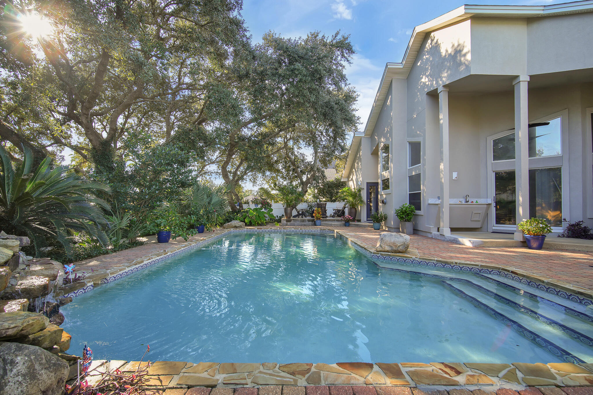 Nestled in a coveted neighborhood with waterfront access to the Santa Rosa Sound and features a New Community Dock. This Residence offers a combination of luxury, comfort, and tranquility, located on a peaceful cul-de-sac. The home features a U-shaped driveway and side-entry garage, A side double gate for extra parking. As you enter the living area you are greeted with 16-18 foot ceilings and an abundance of natural light pouring in through oversized windows, creating a bright and airy atmosphere.This home has been meticulously maintained and recently updated, with a new roof installed in September 2021, a 2024 water heater, new pool pump and well pump for optimal efficiency. The granite outdoor bar and sink area are perfect for hosting gatherings by the pool, while the new stucco on the exterior of the home and all-new landscaping provide a fresh and modern look. Inside, the open floor plan is designed for both ease of living and effortless entertaining. The spacious living room, with its cozy fireplace, flows seamlessly into the formal dining area and chef-inspired kitchen, complete with high-end appliances and ample counter space. The master suite is a true retreat, featuring expansive water views of the pool and a luxurious en-suite bath with a soaking tub, separate walk-in shower, and double vanities.
The backyard is an entertainer's dream, with a massive saltwater pool and a fountain feature surrounded by beautifully laid pavers and lush tropical vegetation. A fireplace provides warmth and ambiance, making the space perfect for year-round enjoyment. The home is equipped with modern lighting and ceiling fans throughout, creating a stylish and comfortable living environment.
Located just minutes from shopping, dining, and recreational activities, this home offers the best of coastal living while ensuring privacy and tranquility. With its ideal location, stunning views, luxurious upgrades, and abundant outdoor space, this home is truly one-of-a-kind. Whether you're relaxing by the pool, enjoying the private beach, or taking in the water views of the pool from your master suite, this property is the ultimate coastal retreat.