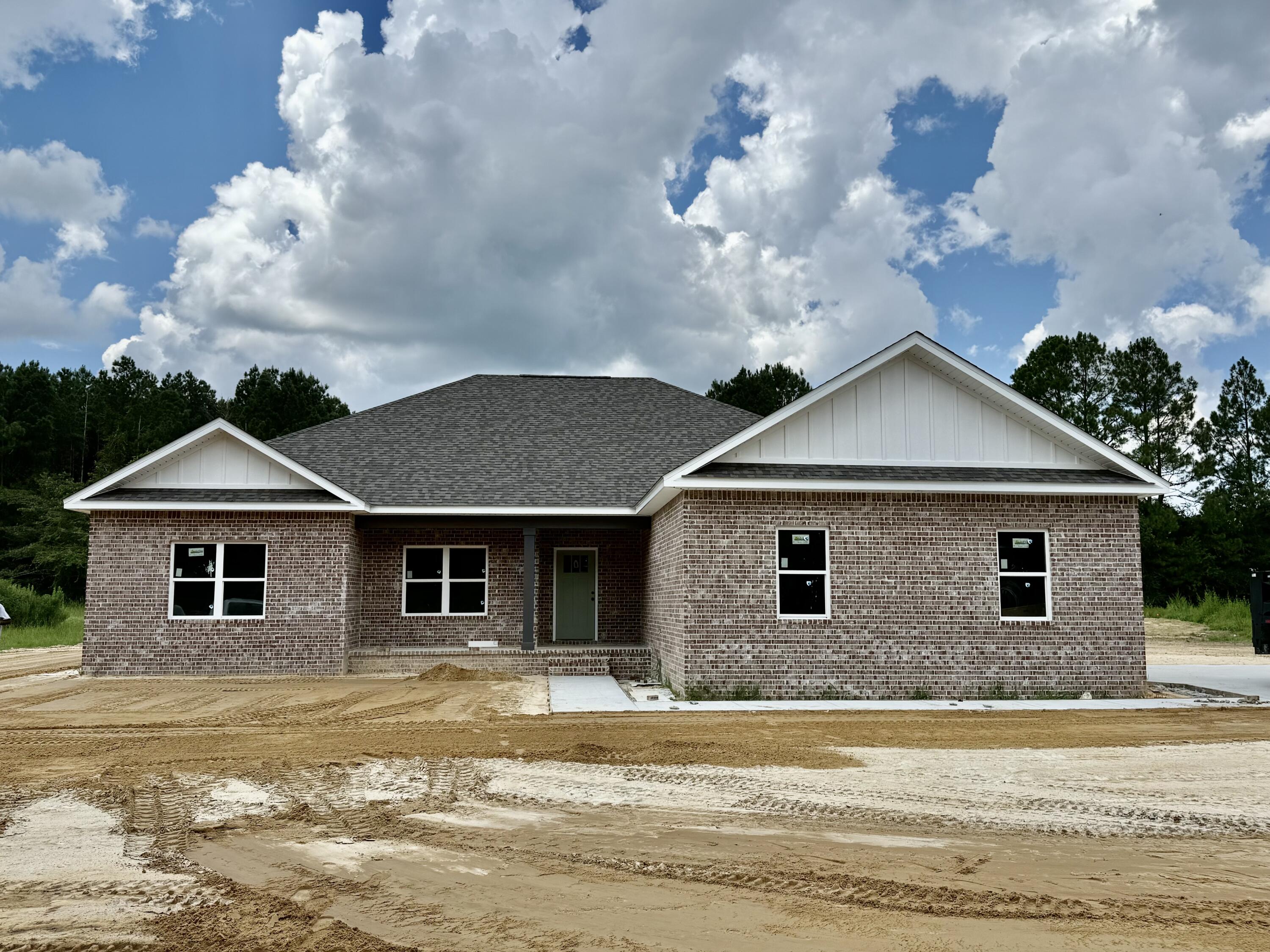 1.74 acre lot and a brand new home! Love the color combination at this beauty! Custom cabinetry, wood look tile throughout. Quartz countertops. This is a 4 bedroom, 2 bath home PLUS office that could easily be used as a guest bedroom or craft room. Stacked stone electric fireplace is a statement piece in the living room as well as a custom barn door to the office! Lot is only partially cleared and goes several hundred feet back into the wooded area. Massive covered back porch has stained wood ceiling. One year builder warranty included!