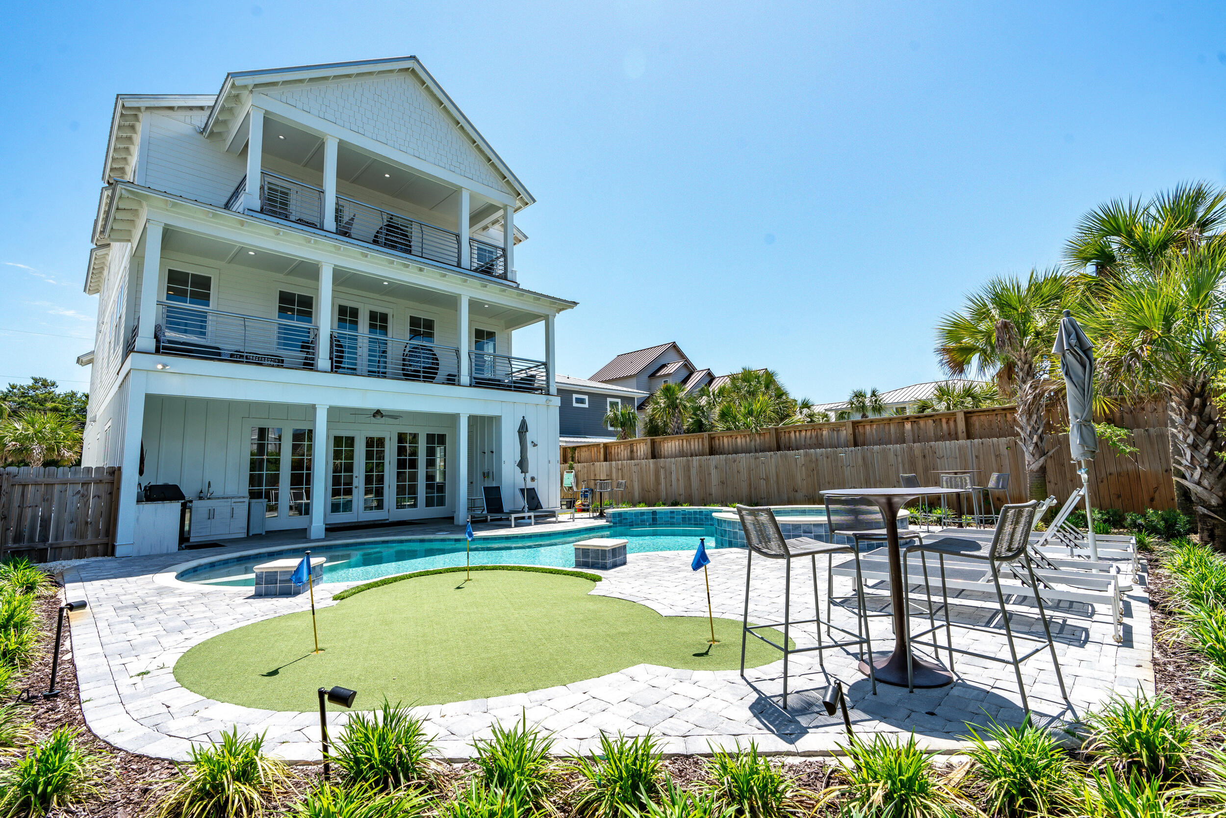 Discover the pinnacle of vacation homes with this opulent 8-bedroom residence in Destin's Crystal Beach area, featuring 9 full bathrooms (8 en-suite) and 3 half bathrooms for unmatched convenience, all just steps from the Gulf of Mexico's pristine sands. This stunning home has been meticulously crafted with no detail overlooked, from its thoughtful design and amenities to its artistic decorations. Throughout the property, shiplap walls add a touch of sophistication, while each suite boasts its own unique theme, featuring a king bed and private bathroom for ultimate comfort and privacy. An elevator enhances accessibility across all floors, ensuring a seamless experience for all guests. As a high-performing vacation rental with an established rental history, property management and future bookings already in place, this property promises not just a home but a lucrative investment. With its blend of sophisticated design, luxury amenities, and a proven track record in the rental market, this home is the epitome of a turnkey vacation rental, ready to deliver an exceptional experience to those seeking the finest in beachside living.

As you enter, be immersed in an atmosphere of sumptuous relaxation with shiplap accent walls and white-painted wooden ceilings that extend from the foyer through the primary living spaces, enhanced by elegant and durable LVP flooring. The ground floor acts as a center of activity, boasting a splendid open-plan chef's kitchen equipped with stainless KitchenAid appliances, bespoke cabinetry, a gas range with a handy pot filler, a built-in wine fridge, and a substantial island with beautiful countertops. This culinary retreat is perfect for preparing gourmet meals and hosting gatherings. Adjacent to the kitchen, a spacious dining area seats 20+ guests and displays unique vintage-style local artwork that accentuates the area's allure. The adjacent living area, adorned with distinctive metal fish wall art, includes a large wall-mounted TV and an L-shaped sofa for peak relaxation. This level also hosts two king suites, each with tiled walk-in showers; one suite additionally features a large bathtub, offering serene retreats for guests. Completing the ground floor's practical elegance is a conveniently located half bathroom, a fully equipped laundry room concealed behind a barn door, and an elevator, ensuring effortless access to all levels.

Step directly from the first floor into the meticulously crafted backyard, designed with entertainment in mind. This outdoor sanctuary features a covered summer kitchen equipped with a grill, ice maker, sink and beverage fridge. Adjacent to this area is a half bathroom, enhancing guest comfort and accessibility during outdoor dining and socializing. The arrangement is flawlessly complemented by an array of outdoor furnishings, making every gathering seamless and enjoyable. At the core of this retreat is an immense heated saltwater pool, complete with a waterfall wall, tanning ledge and built-in concrete stools, creating a tranquil setting for relaxation and fun. The pool area is accompanied by a luxurious spa and a three-hole putting green, offering a mix of leisure activities that cater to all ages. Lush, tropical landscaping and landscape lighting envelop the space, enhancing the resort-like ambiance that makes every stay feel like a luxurious escape.

Guests can ascend to the second floor either via the elevator or by walking up the wooden stairs, passing through a staircase adorned with shiplap accent walls and unique art, adding a whimsical touch to the ascent. Once upstairs, the main hallway captivates with cool, surf-themed decor, including surfboards mounted as striking wall decorations. This level offers three king suites, each individually themed & decorated for comfort and privacy. An additional half bathroom on this floor ensures accessibility and ease for guests. The second living room serves as a sanctuary for relaxation and entertainment, creating the perfect ambiance for gatherings or tranquil evenings that features a  pool table, shuffleboard and a beverage fridge. A large covered balcony overlooking the pool area provides a sublime setting for morning coffees or sunset cocktails. Additionally, a small balcony on the front of the house, accessible from both one of the bedrooms and a hallway door, enhances the indoor-outdoor flow and offers multiple vantage points to enjoy the surroundings.

Ascend to the third floor and enter a space designed for entertainment and relaxation. At the top of the stairs, guests are greeted by a vibrant collection of artwork featuring celebrities whimsically reimagined as cats and dogs, can you identify all of them? This level houses a dynamic third living area, complete with a wall-mounted TV, sofa and three arcade games alongside a convenient beverage fridge, making it the perfect spot for family fun and leisure. The third floor also offers three king suites, each providing exceptional comfort and privacy. Each suite is uniquely designed with a walk-in tiled shower, and one includes a separate bathtub, adding a spa-like experience. For additional convenience, this floor includes a full bathroom accessible to guests and six custom twin bunks, thoughtfully integrated to accommodate larger groups or families. Adding to the allure, a large covered balcony with outdoor seating overlooks the pool area. This balcony is accessible directly from one of the bedrooms, offering a private retreat, while other guests can access it from the living area, seamlessly blending indoor luxury with outdoor beauty.

This distinguished property highlights an established rental history, meticulous attention to detail, captivating architectural elements, and a stunning array of carefully curated artwork, creating a vibrant atmosphere. As a top-performing vacation rental with property management and future bookings already in place, this property is not just a residence but a profitable investment, blending sophisticated design with luxury amenities and a proven track record in the rental market.