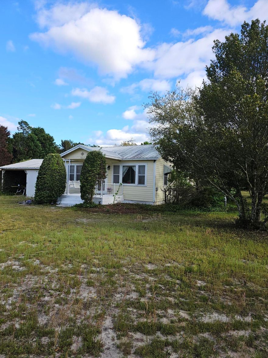 Adorable Florida Cottage on over an ACRE! You first walk into the living room and to the left you will find the two bedrooms with wood flooring and a bathroom. To the right of the living room is the dining room that leads into the kitchen. With the laundry room conveniently placed next to the kitchen. Enjoy the outdoor living of Florida in the enclosed Florida room. In the back of the massive property you will find multiple sheds and fully fenced. This property has tons of potential. There is no HOA, so short term destination is possible. Plenty of space to add on as well! Only 4 miles Florida's longest fishing pier. The home and sheds are being sold AS-IS. This beautiful property is ready to max out it's full potential.