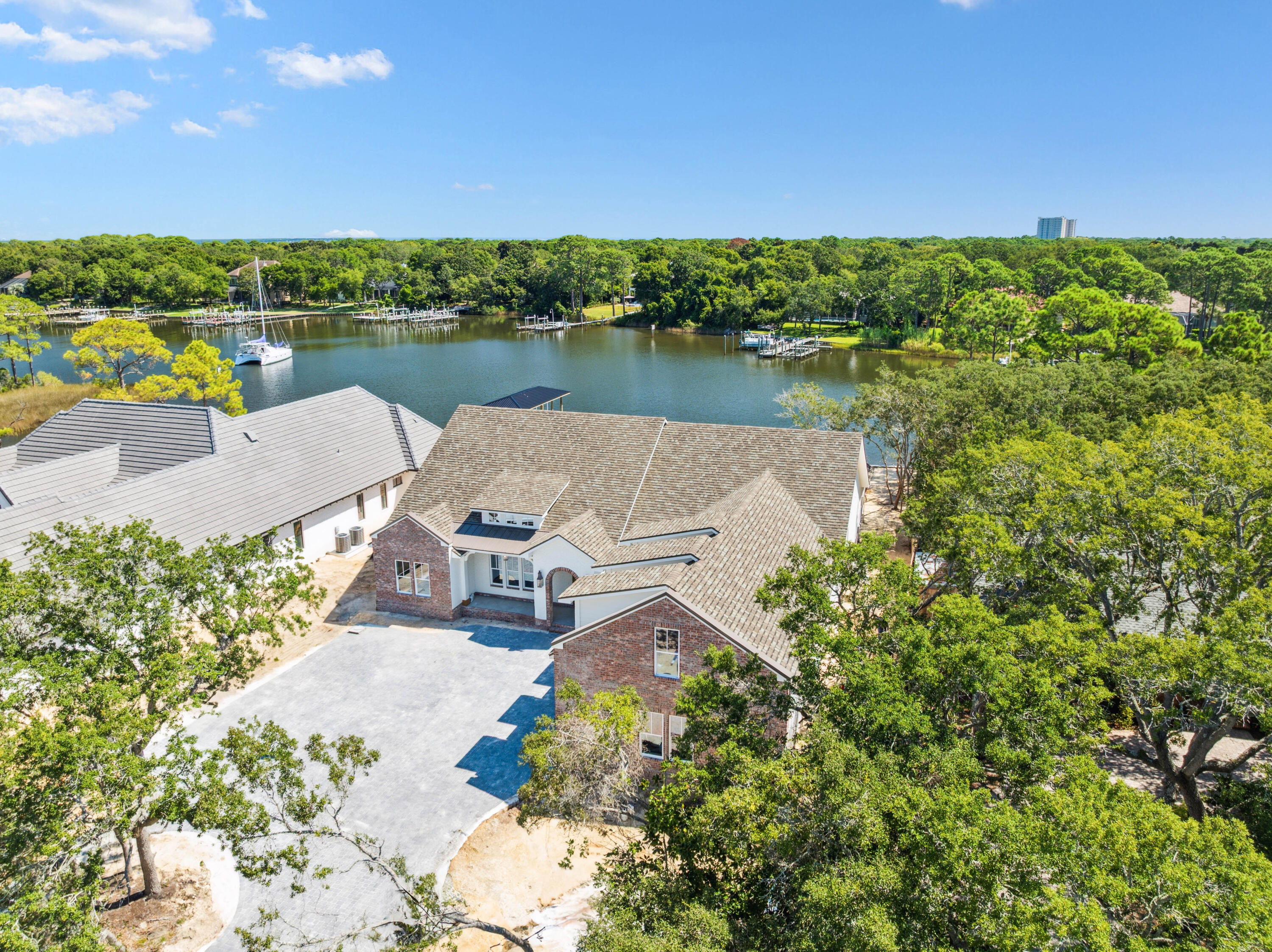 Life on the water takes center stage in this newly constructed Reiker Homes residence offering more than 4,500 square feet of refined living space. With 100 feet of deepwater frontage and seamless access to Choctawhatchee Bay and the Gulf of Mexico, this property delivers the ultimate boater's lifestyle.Designed primarily on one level, the home features four bedrooms, four and a half baths, a three-car garage, and a dedicated office. Expansive windows and French doors frame sweeping water views from both the open living spaces and the master retreat, where a fireplace adds warmth and elegance. The kitchen is a chef's dream with Thermador appliances, a farmhouse sink, custom pantry shelving, and an ice maker, while oak hardwood floors and marble and quartz surfaces extend throughout. Guests enjoy privacy with the thoughtful split floor plan, plus a versatile upstairs bonus room ideal as a media lounge, game space, or additional office. Outdoors, a paver pool and spa invite endless entertaining alongside a fully equipped summer kitchen with covered dining. A new deepwater dock is underway, with opportunities for customization by the future owner.
Set amid live oaks and magnolias, and just minutes from the private Destin airport, this estate combines natural beauty, luxury finishes, and unparalleled access to the open waters of the Emerald Coast.