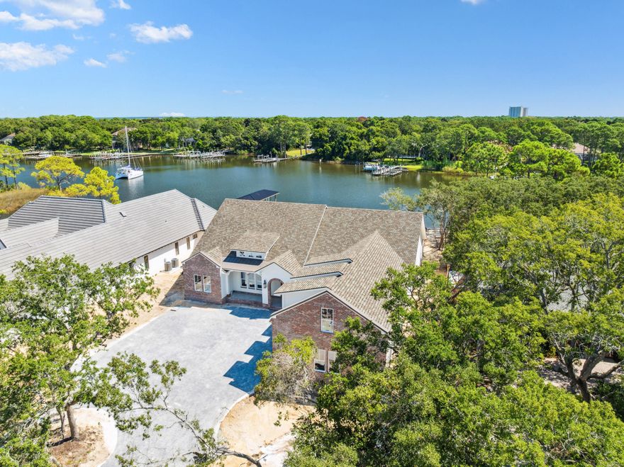 Life on the water takes center stage in this newly constructed Reiker Homes residence offering more than 4,500 square feet of refined living space. With 100 feet of deepwater frontage and seamless access to Choctawhatchee Bay and the Gulf of Mexico, this property delivers the ultimate boater's lifestyle.Designed primarily on one level, the home features four bedrooms, four and a half baths, a three-car garage, and a dedicated office. Expansive windows and French doors frame sweeping water views from both the open living spaces and the master retreat, where a fireplace adds warmth and elegance. The kitchen is a chef's dream with Thermador appliances, a farmhouse sink, custom pantry shelving, and an ice maker, while oak hardwood floors and marble and quartz surfaces extend throughout. Guests enjoy privacy with the thoughtful split floor plan, plus a versatile upstairs bonus room ideal as a media lounge, game space, or additional office. Outdoors, a paver pool and spa invite endless entertaining alongside a fully equipped summer kitchen with covered dining. A new deepwater dock is underway, with opportunities for customization by the future owner.
Set amid live oaks and magnolias, and just minutes from the private Destin airport, this estate combines natural beauty, luxury finishes, and unparalleled access to the open waters of the Emerald Coast.