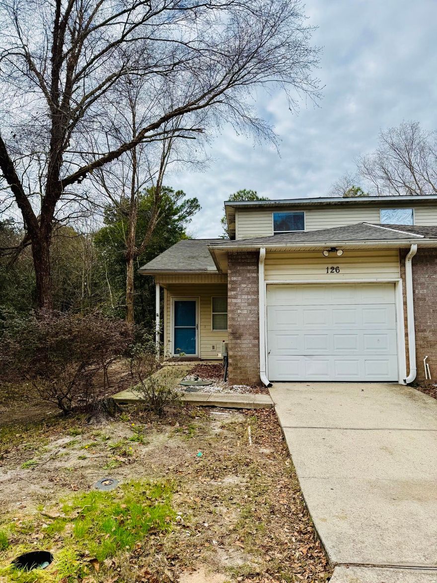 Nestled amidst serene natural surroundings, this beautifully maintained end-unit home offers the perfect blend of convenience and privacy, located just 2.2 miles from Hurlburt Field.Step inside to a bright and airy open floor plan highlighted by soaring ceilings and abundant natural light. The first floor features durable laminate flooring throughout, creating a cohesive and low-maintenance living space. The spacious kitchen is a chef's dream, complete with a center island, stainless steel appliances, Corian countertops, ample cabinetry, and a pantry for added storage.The first-floor primary suite provides a private retreat, featuring a large walk-in closet and an en-suite bath with a separate soaking tub and stand-up shower. Additional storage is conveniently tucked under the staircase to keep the home organized.

Upstairs, you will find two generously sized bedrooms with large closets, a full bath, and newer carpet installed approximately one year ago. The home also received a new roof around the same time, offering peace of mind for years to come.

Thoughtful upgrades include high-end ceiling fans throughout, excellent insulation, a storm door, and a pull-down screen for added comfort and energy efficiency. Indoor laundry hookups further enhance everyday convenience.

The one-car garage is equipped with a generator transfer station, while private covered front and back porches provide inviting spaces to relax and unwind. No HOA, offering added flexibility and freedom.

