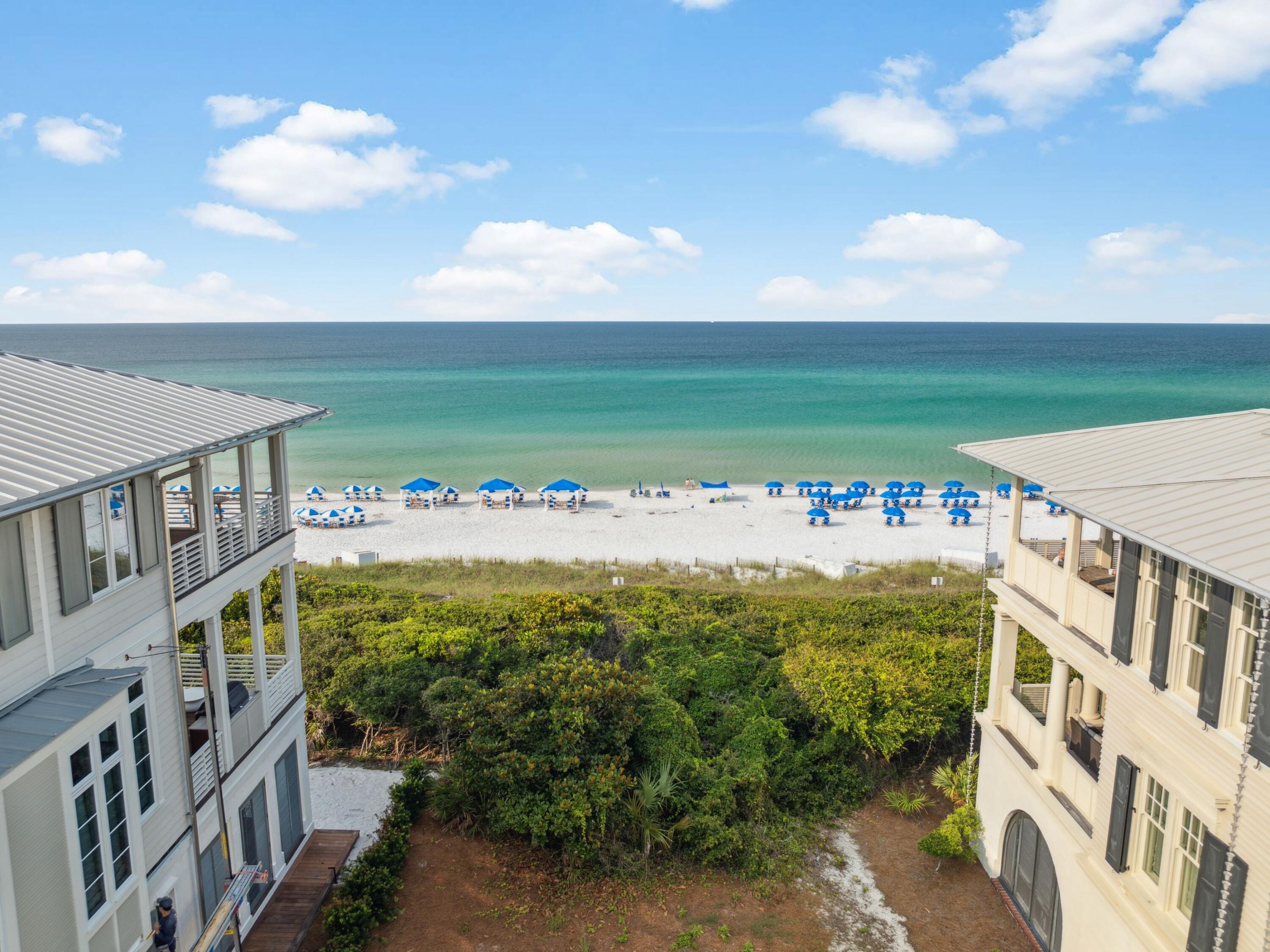 One of the last remaining Gulf-front lots in Seaside, Florida, this exceptional property offers a rare opportunity to create a bespoke coastal estate in one of 30A's most iconic communities. Approved architectural plans convey with the sale, showcasing a thoughtfully designed residence spanning over 5,800 square feet. The proposed design features a three-story main dwelling and a two-story guest suite above the garage, connected by a covered walkway. Highlights include three spacious Gulf-facing porches, a rooftop terrace, a private pool, and beautifully landscaped outdoor spaces. This is a lot listing with architecturally approved plans. The images shown are renderings representing the proposed home design for the lot; construction has not yet begun. Final exterior and interior renderings are forthcoming.
Inside, the plans call for a total of eight bedrooms, including a luxurious third-floor primary suite with private balcony access and panoramic Gulf views. The main house features open-concept living and dining areas, a chef's kitchen, a spiral staircase, elevator access to all levels, and carefully curated architectural details throughout. The guest suite offers separate living quarters, ideal for hosting friends or extended family. Durable all-concrete construction and V-crimp metal roofing ensure both strength and longevity.
Located just steps from the Town Center, this property is walking distance to Seaside's renowned dining, shopping, and cultural experiences. Owners enjoy access to community amenities including pools, tennis and pickleball courts, and a fitness center. Whether you're envisioning a full-time residence, a vacation home, or an investment property, this offering is unmatched in location, design, and lifestyle potential.