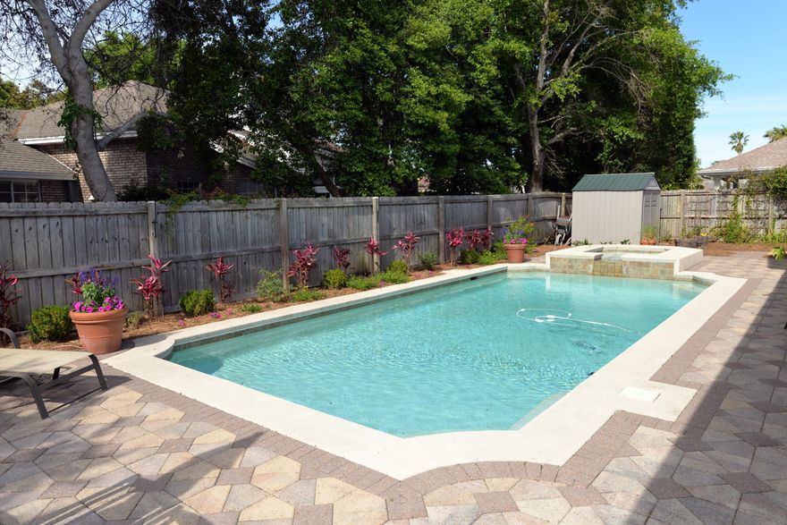 HAPPY HAPPENS HERE! Live in the heart of paradise  walk to all of the festivities at Harborwalk Village! This brick four bedroom, three bath home is enhanced by a beautiful fenced back yard featuring a sparkling pool surrounded by an abundance of pool decking & yard. Enjoy picnics, swimming, or just relaxing in the shade of the poolside covered patio. Property has been well-maintained & updated. It has a master suite down as well as up in addition to two other downstairs bedrooms which share a third bath. The upstairs consists of a very large bedroom & bath. The kitchen & laundry room sport pretty granite counter tops & white cabinets. Other amenities include a wood-burning fireplace surrounded by built-in bookshelves in the living room, a spacious dining room, nine