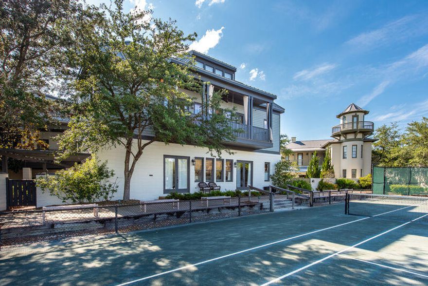 Modern sensibility in this exquisite renovation. 5 BR (plus loft) / 5 BA home and carriage house. Situated fronting the tennis courts on one of the main boardwalks that leads to Rosemary Beach's four pools, Eastern Green and beach, location is ideal. An oversized lot provides the setting for a beautiful private brick courtyard and lawn with ample space for both the main and carriage houses to enjoy, not often found in Rosemary Beach. A wonderful built in seating area with fire pit is located at one end of lawn. Entering the the main house from the courtyard you find a sunroom style kitchen and dining room, enhanced by charming ten foot heart pine doors that let outdoor beauty shine in. A brick wall, concrete floors, granite countertops, 11 foot ceilings