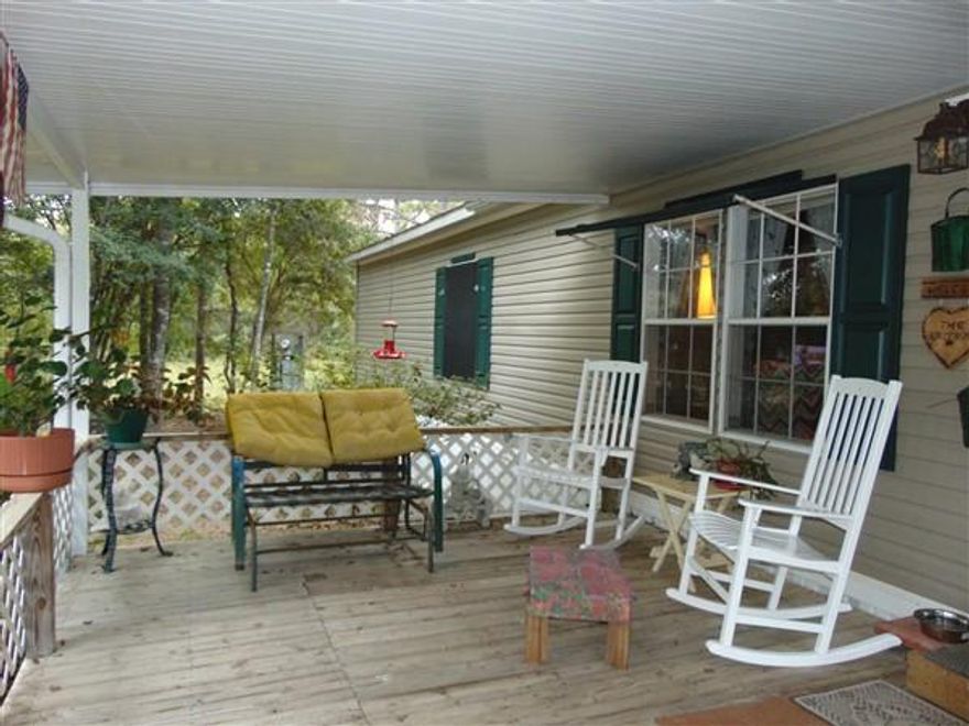 Wonderful one owner home with beautiful views of Juniper Lake and access to community area for fishing off the bank (primarily catfish, Bream & Bass). 1998 Fleetwood was originally placed on this lot & will qualify for FHA & VA financing. Property is entirely fenced. Detached 2-car carport with 10x10 storage building, 16x16 workshop on concrete slab with power and additional 10x10 tool shed. Interior features include open floor plan, wood-burning fireplace, laundry. The kitchen has lots of cabinets & built-in display cabinets, as well as a large kitchen island. Master BR has large walk-thru closet with entry from BR & from master bath. Master bath has double vanities, Whirlpool tub & separate walk-in shower. 12x27 covered porch overlooks the lake. Schedule your showing today!!
