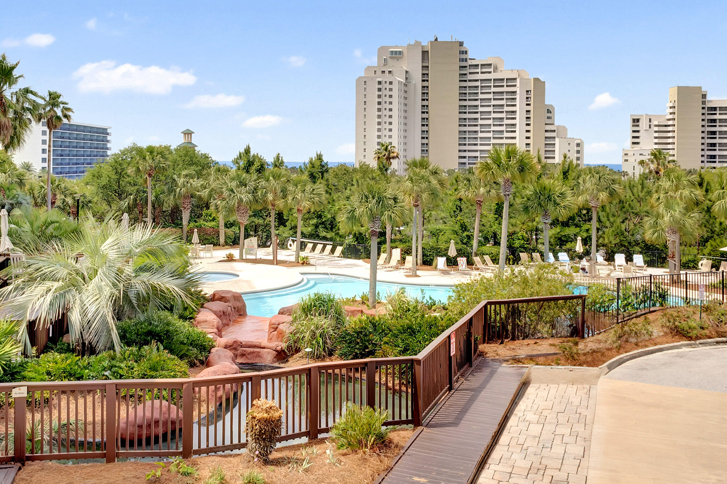 Nestled on the 2nd floor of Luau I, this exceptional corner residence boasts a spacious 388 sqft covered balcony, commanding breathtaking views of the tropical pool area and a tantalizing glimpse of the gulf beyond. Throughout the entire condo, elegant tile flooring creates a seamless and stylish ambiance. Notably, the residence is equipped with a 2014 hot water heater and thoughtful handicapped accessible features, including convenient roll-under sinks and sturdy handle bars, ensuring both comfort and accessibility for all. Luau offers an oasis getaway with a heated pool, relaxing waterfall, hot tub, and grilling area. In addition, owners can take advantage of the sundeck on the top floor with panoramic views from the gulf to the bay or burn some calories in the fitness center. Luau is on the beachside of Sandestin across from the beautiful white sandy beaches and just a tram ride to the all the amenities that the resort offers.
As an introduction to the Sandestin lifestyle, we invite our new owners to explore amenities that make Sandestin special. The listing brokerage and seller(s) are presenting the buyer(s) of this property with (2) 90-minute rounds of Tennis court time, a golf foursome at one of our three championship courses, and a round of golf for up to four (4) players at the unrivaled Burnt Pine Golf Club.
Sandestin Golf and Beach Resort features more than seven miles of beaches and pristine bay front, four championship golf courses, 15 world-class tennis courts, a 226-slip marina, a fitness center, spa and celebrity chef dining. Shop, dine and play at the charming pedestrian village, The Village of Baytowne Wharf and more. Inside the gates of the resort, residents enjoy a balanced lifestyle of high-class living, spanning the 2,400 acres from the beach to the bay. Everything within the gates of the resort is accessible by golf cart or bicycle. The entire resort is interconnected by miles of pedestrian, bike and golf cart paths that weave through groves of live oaks, meandering past natural lagoons, fountains, man-made lakes, and meticulously landscaped fairways.