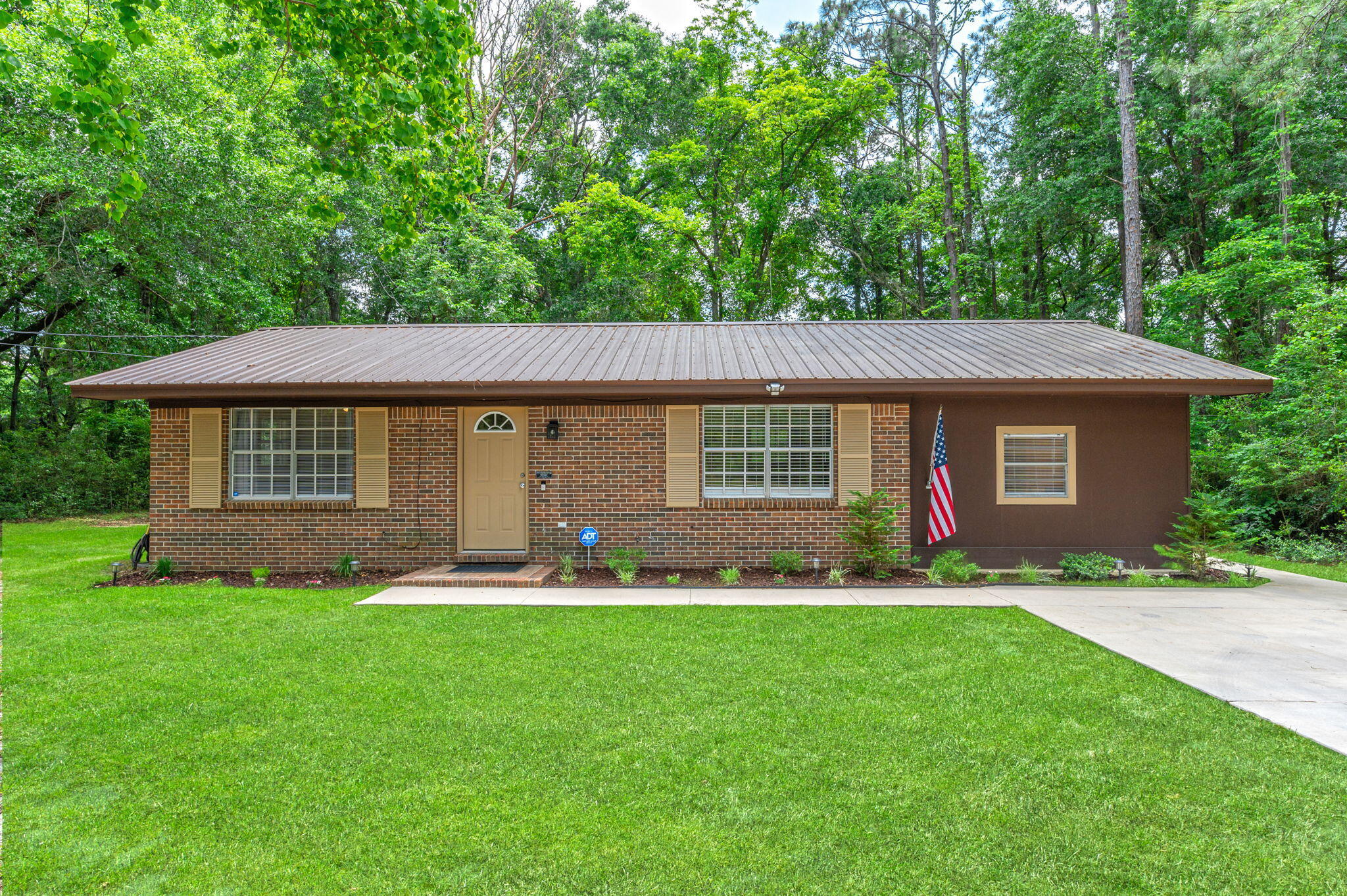 Nestled on a sprawling half-acre plot, this charming small brick home has undergone extensive renovations, combining classic architecture with modern amenities. Inside, the kitchen boasts stainless steel appliances, set against updated flooring that extends throughout the home. A new septic system and drain field, recently installed, ensure environmental efficiency and sustainability. The exterior features a durable metal roof, added in 2021, which complements the well-maintained brick facade, offering both aesthetic appeal and protection against the elements. This property merges the warmth of traditional design with the conveniences of modern living, making it an ideal sanctuary. This home is convenienlty located to military bases, beaches, shopping and entertainment areas.