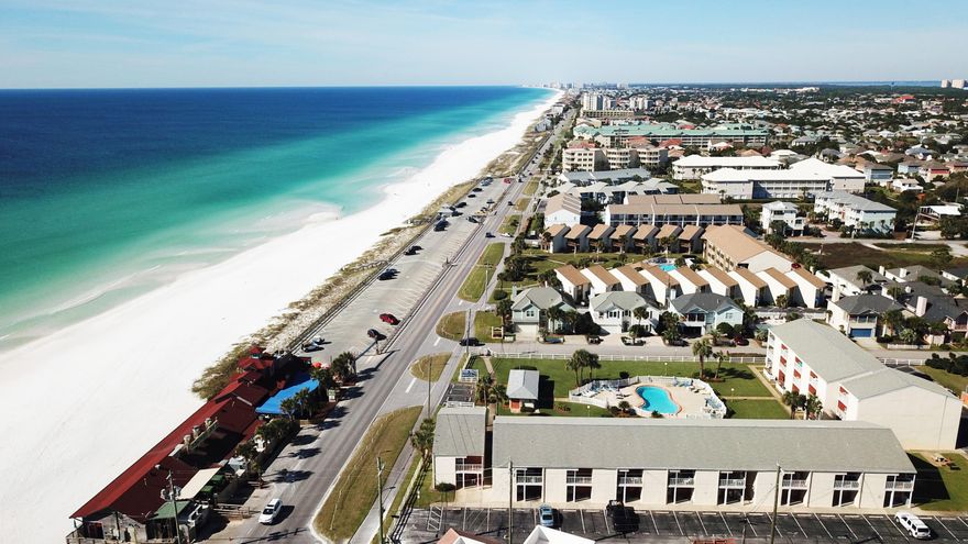 For those who love the Gulf Coast beach scene while valuing privacy, low density and single floor living, this Tradewinds first floor condo delivers on that and more. The unit evokes elegant color tones punctuated with crisp white trim and easy care tile floors. The open concept features a cozy bistro-style dining area flanked by a half wall at the kitchen and a living room which opens via sliding glass doors to a wonderful covered patio. The immaculate kitchen is bright, cozy and functional with stainless steel sink and open shelves. The master bedroom also opens to the patio, and both bedrooms have a full private bath. A stackable washer and dryer make life easy, while the ground floor adds convenience to the swimming pool, green space, grills and picnic areas.