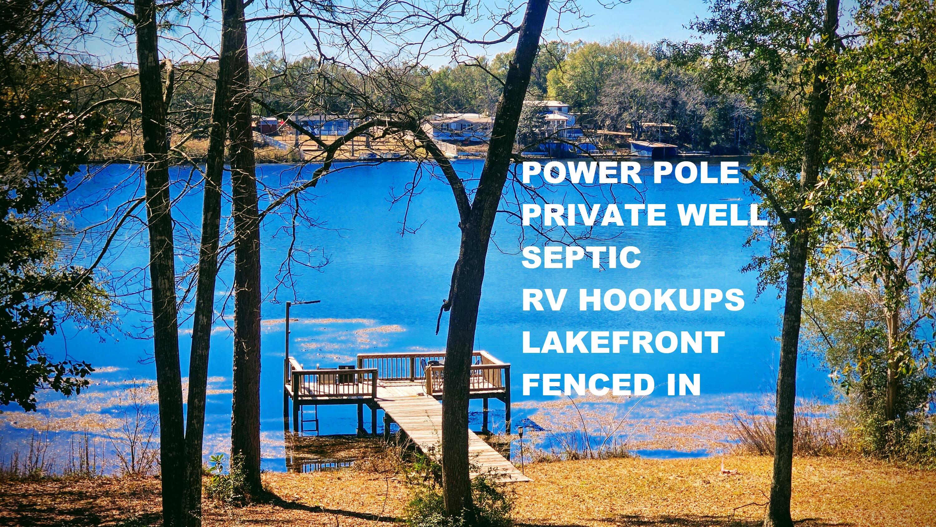 Campers dream lot or a perfect  place to build your lakefront home! The lakefront views include amazing sunsets. The cleared lot slopes down to Juniper Lake and includes a dock for fishing. Juniper Lake contains bass, crappie, and catfish. Enjoy feeding the turtles from the dock too. Fish from the dock or take a boat out to the middle of the lake. Property includes power pole with multiple 30amp recepticles for RVS. Water well attaches to multiple faucets around the property. Septic tank on site. City water is avaialble. Property is fenced in with two double gates. Easy entry and exit for RV. Seller/Selling Agent is a Florida Real Estate Agent that owns the property