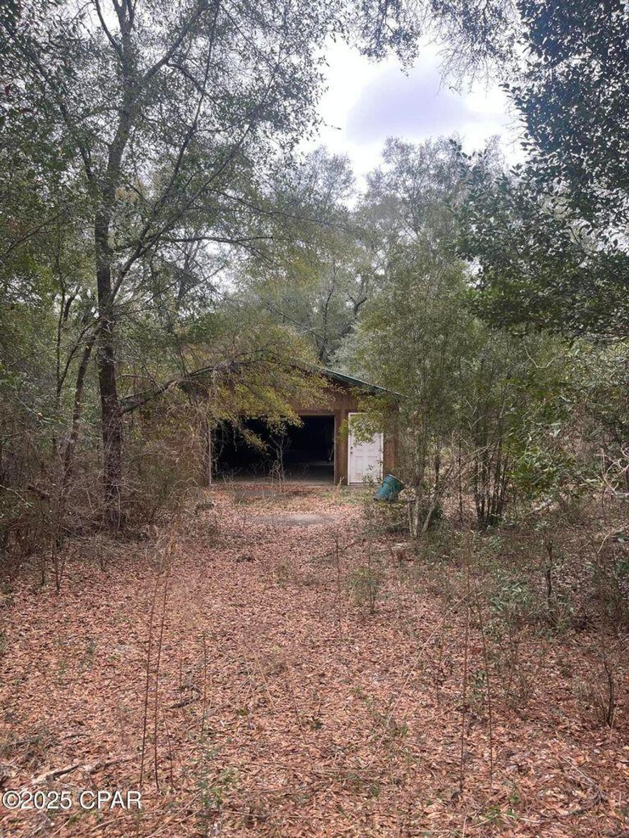 : If you are looking for a wooded and secluded location south of the Holt exit on Interstate10 - this 24' x 36' shop with electricity (currently turned off) has endless possibilities. Workshop with garage door and 2 additional doors is nestled in the nearly 2.5 acre wooded property. Underground electricity, concrete floor and short ramp at garage entry embody the care given to its construction. Well is on property but has not been used in several years. Sellers own 426 and 428 Fox Lane and are only selling together.